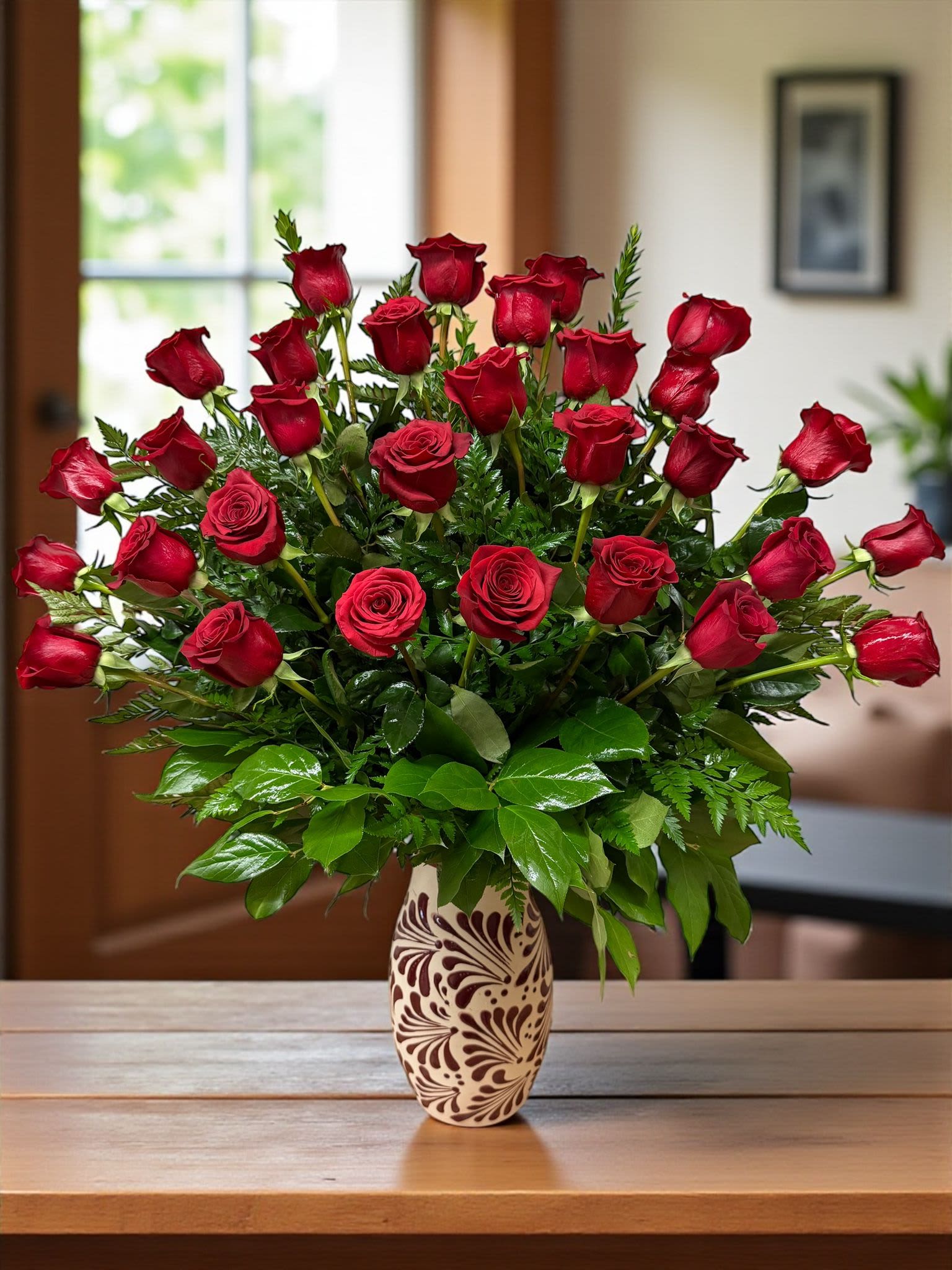 Red roses arranged in a patterned vase