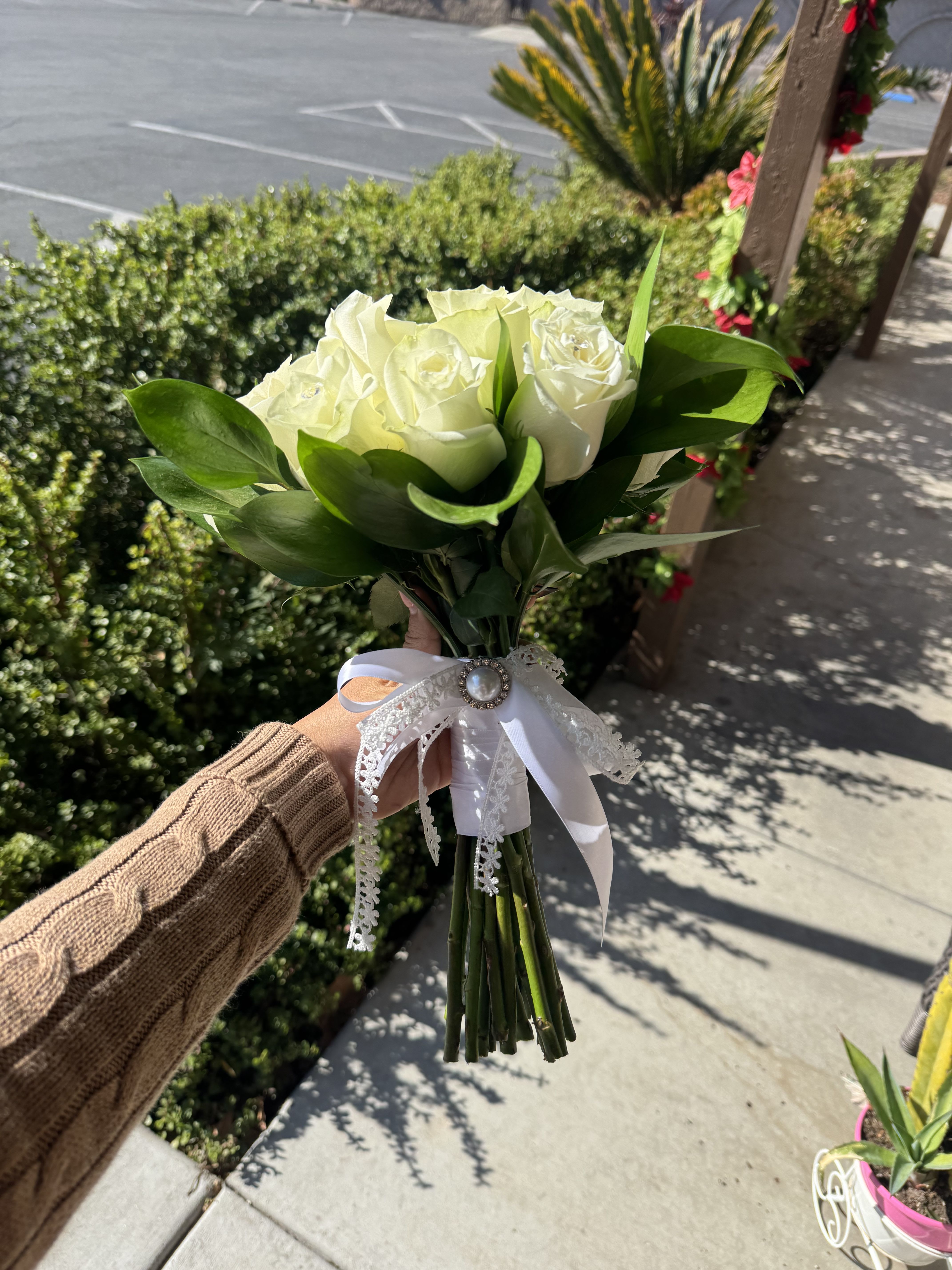 Handheld bouquet of white roses with a lace ribbon bow