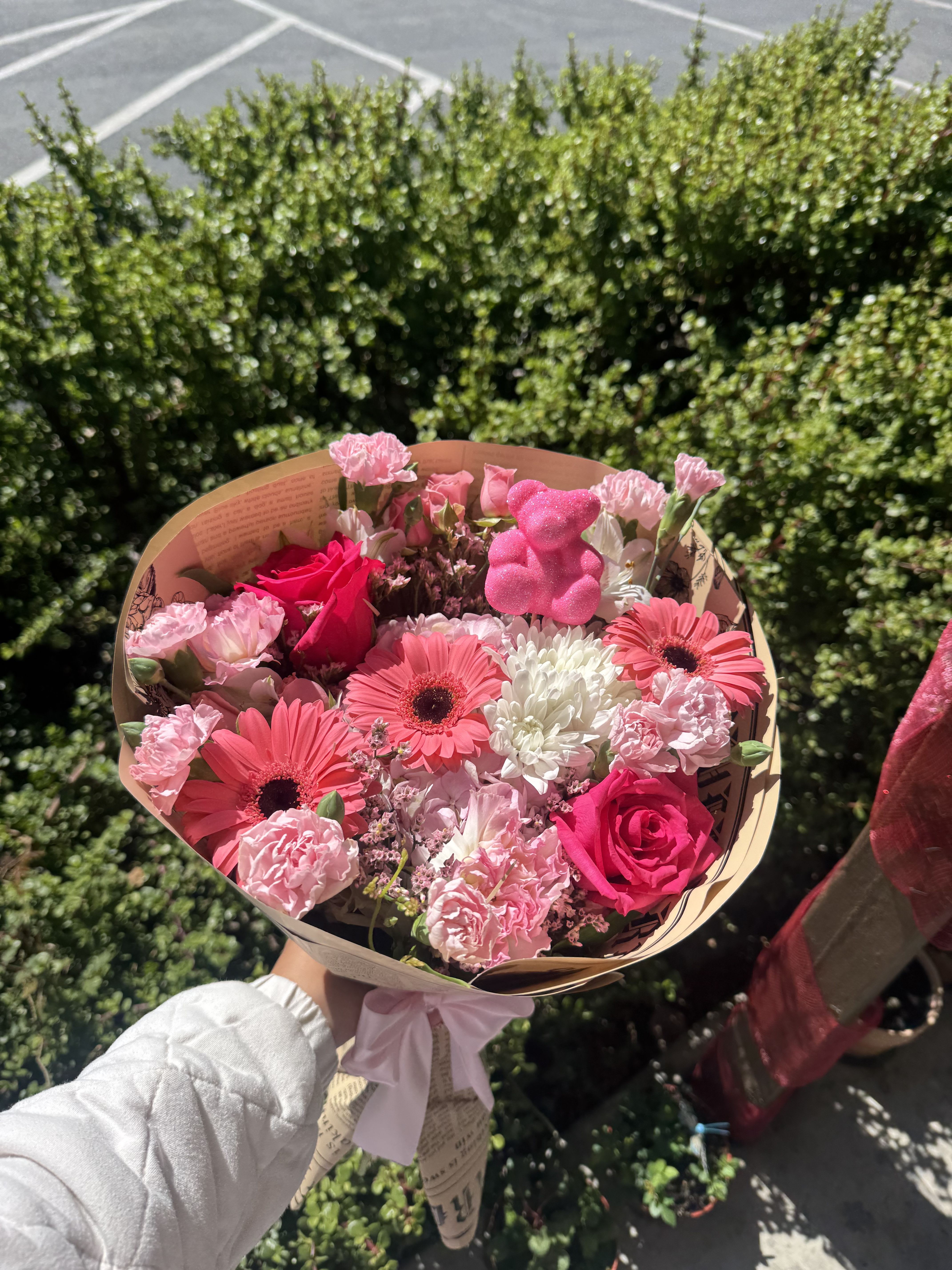 Pink mixed flower bouquet with roses and gerbera daisies wrapped in paper