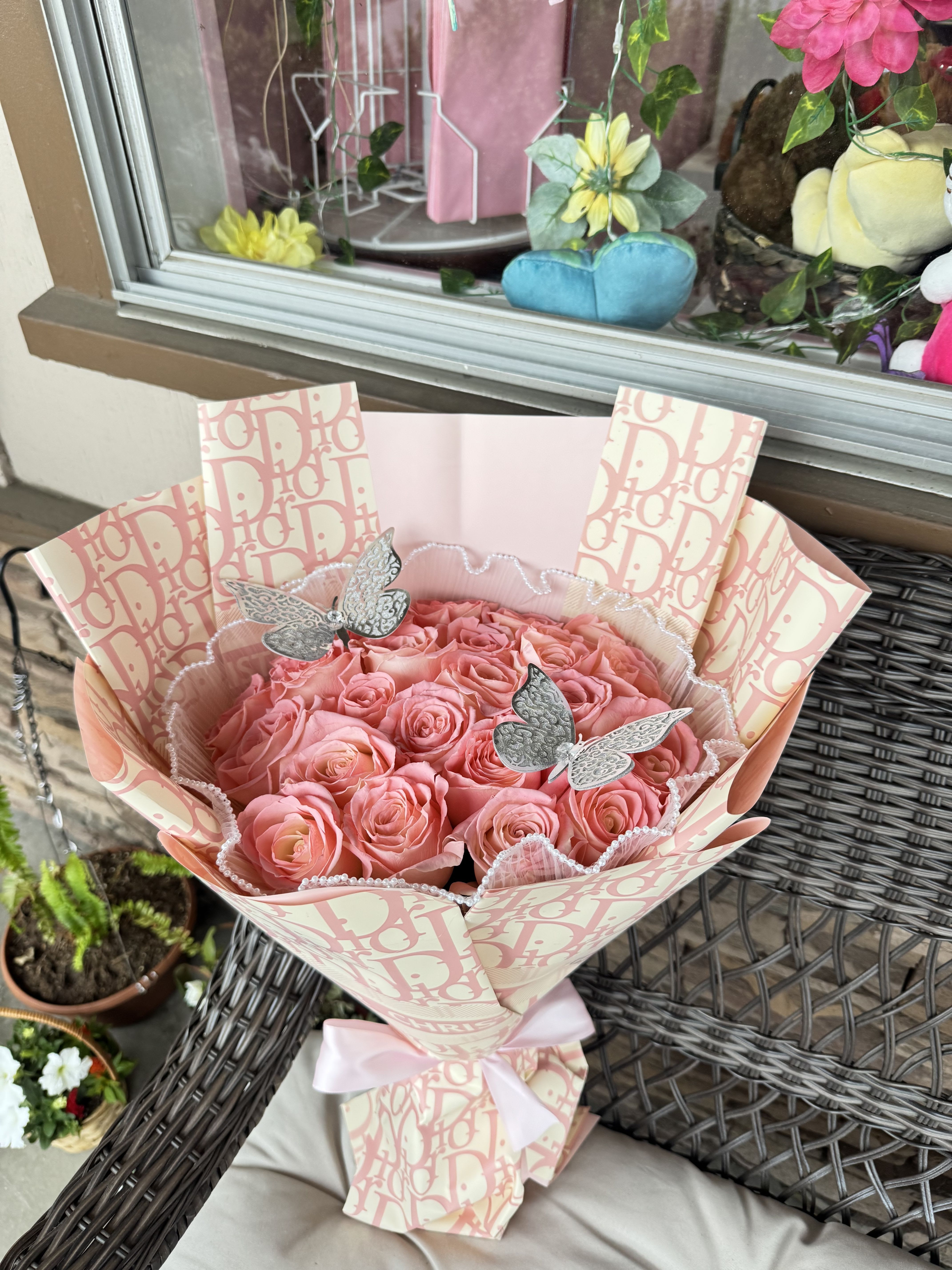 Bouquet of pink roses wrapped in patterned paper with a pink ribbon