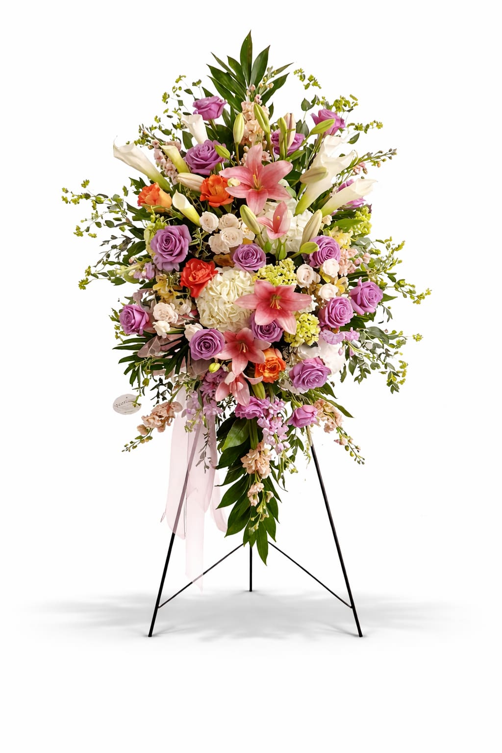 Standing floral spray with pink lilies, purple roses, and white blooms