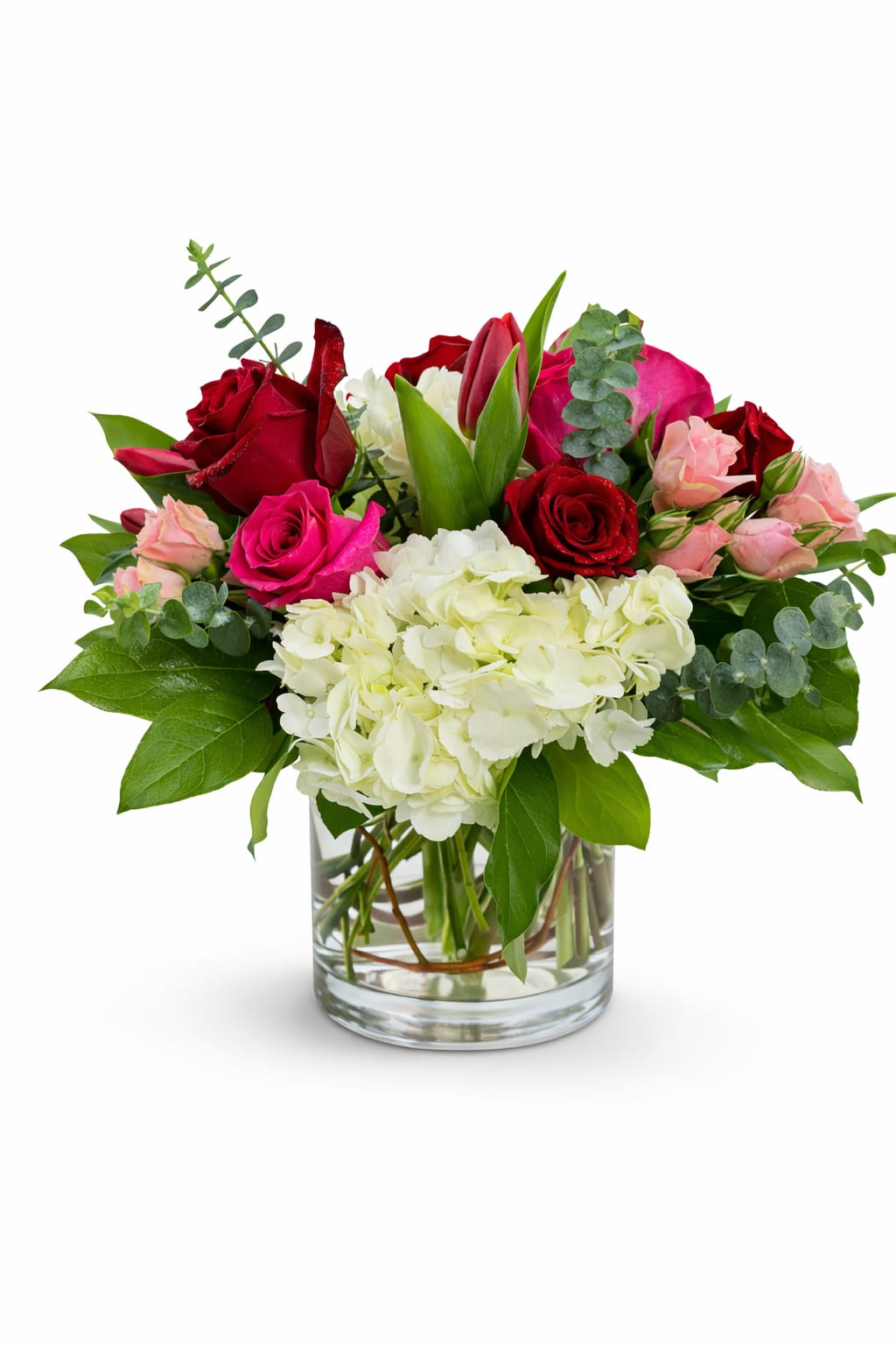 Bouquet of red and pink roses with white hydrangea in a glass vase