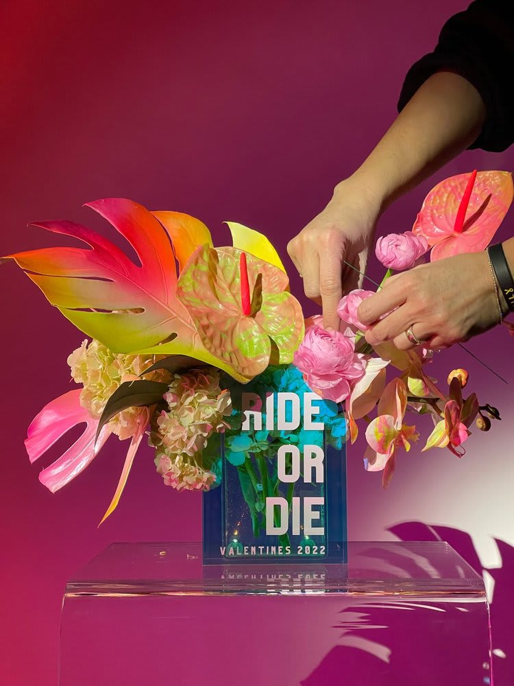 Tropical floral arrangement with pink blooms in a clear vase