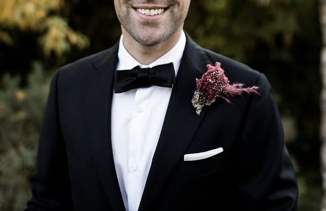 Man in tuxedo wearing a pink boutonniere on his lapel