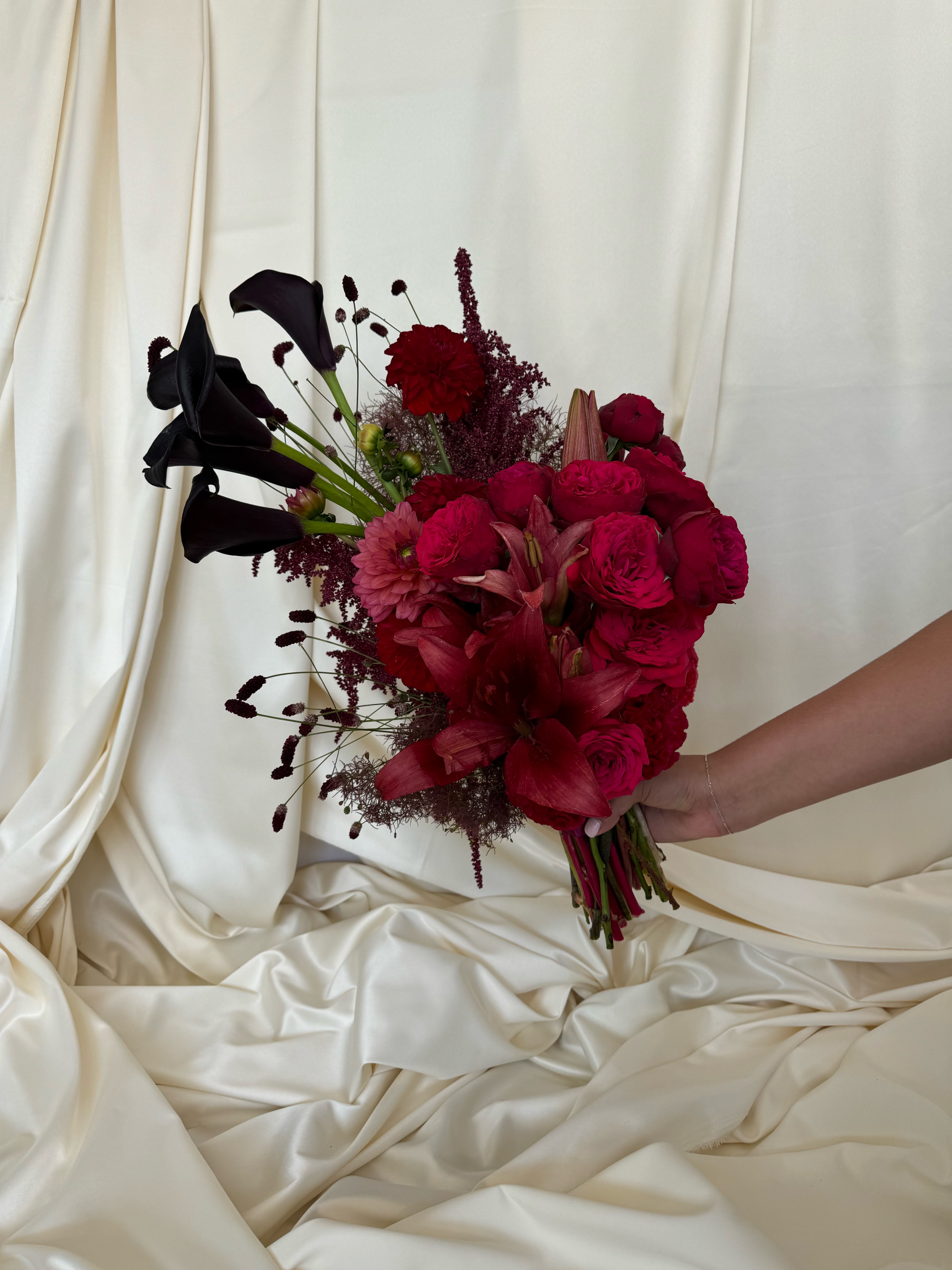 Bouquet of deep red flowers with black calla lilies