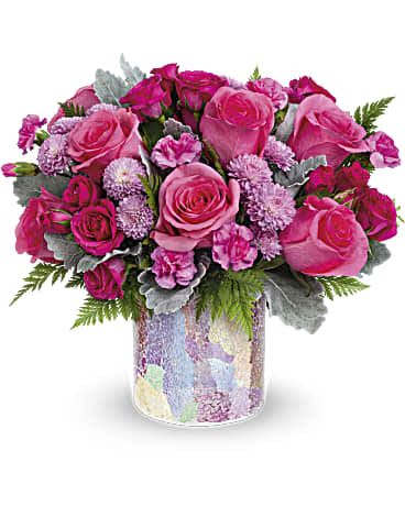 Pink roses and carnations arranged in a patterned glass vase