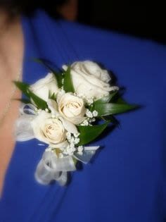 White rose corsage with ribbon on a blue dress