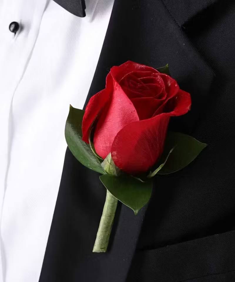 Red rose boutonniere on a black suit jacket