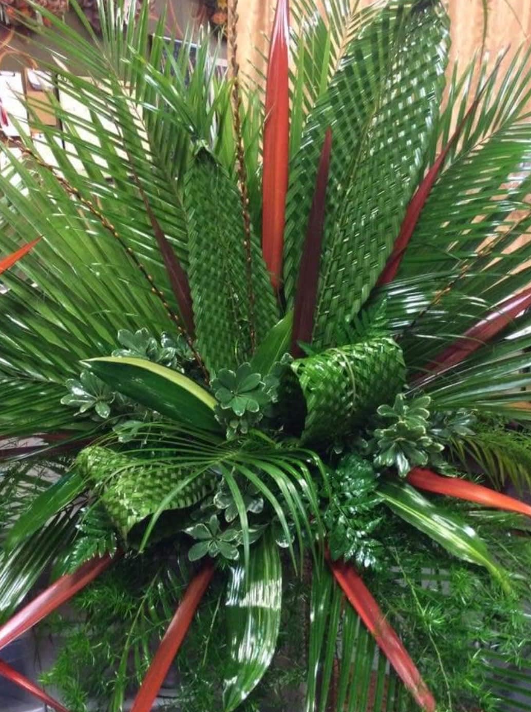 Large tropical arrangement of palm fronds and red-tipped foliage