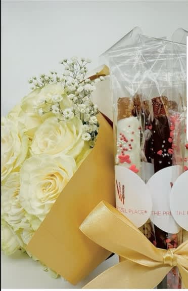 White rose bouquet beside wrapped chocolate bars in clear plastic