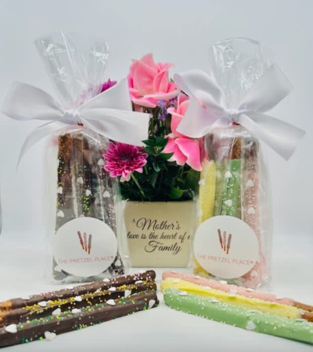 Gift set with pink flowers and decorated pretzel rods in clear bags