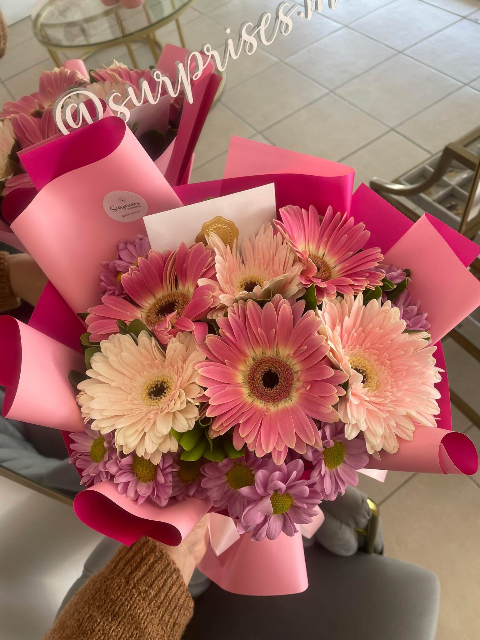 Pink and cream gerbera daisy bouquet wrapped in pink paper