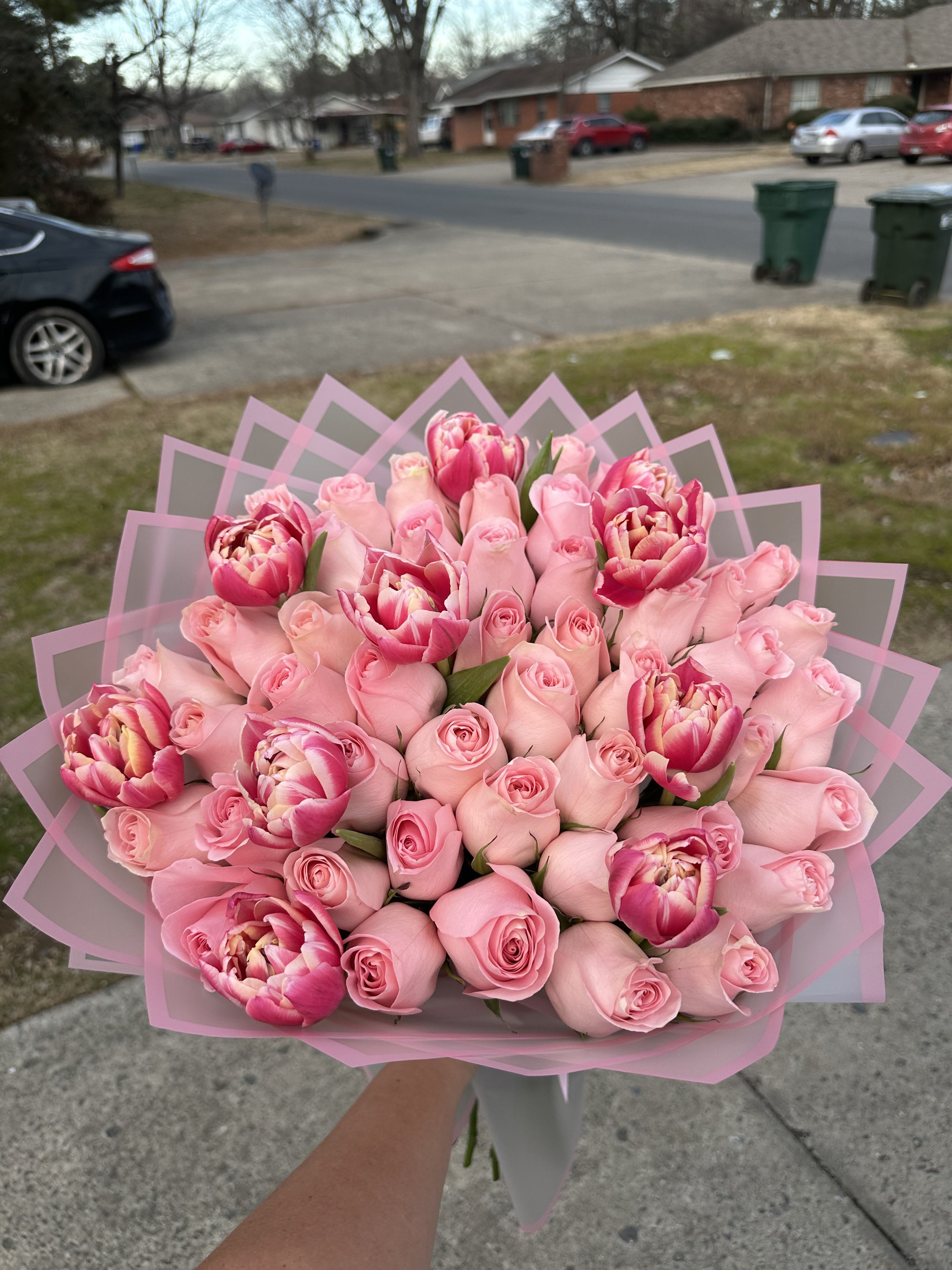 Bouquet of pink roses and pink tulips wrapped in pink paper