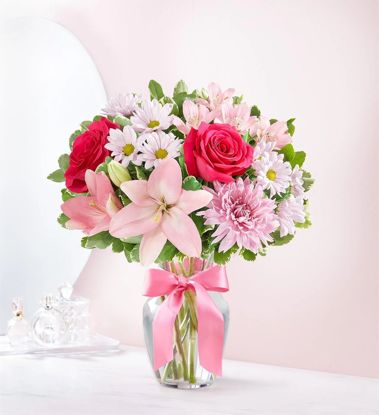 Mother’s Embrace - Celebrate Mom and her lifetime of comforting hugs with our Mother’s Embrace bouquet. This beautiful arrangement features pink and lavender blooms designed by hand in a classic clear glass vase, making it the perfect way to express your love and gratitude.