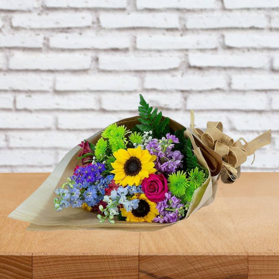 Spring Mix flowers Wrapped Bouquet Daily Special - Celebrate spring in style with the sale of our Spring Wrap Bouqu! This beautiful bouquet features the perfect combination of roses, sunflowers, alstroemeria, chrysanthemums, and delphinium artistically grouped in a durable kraft paper wrap. 