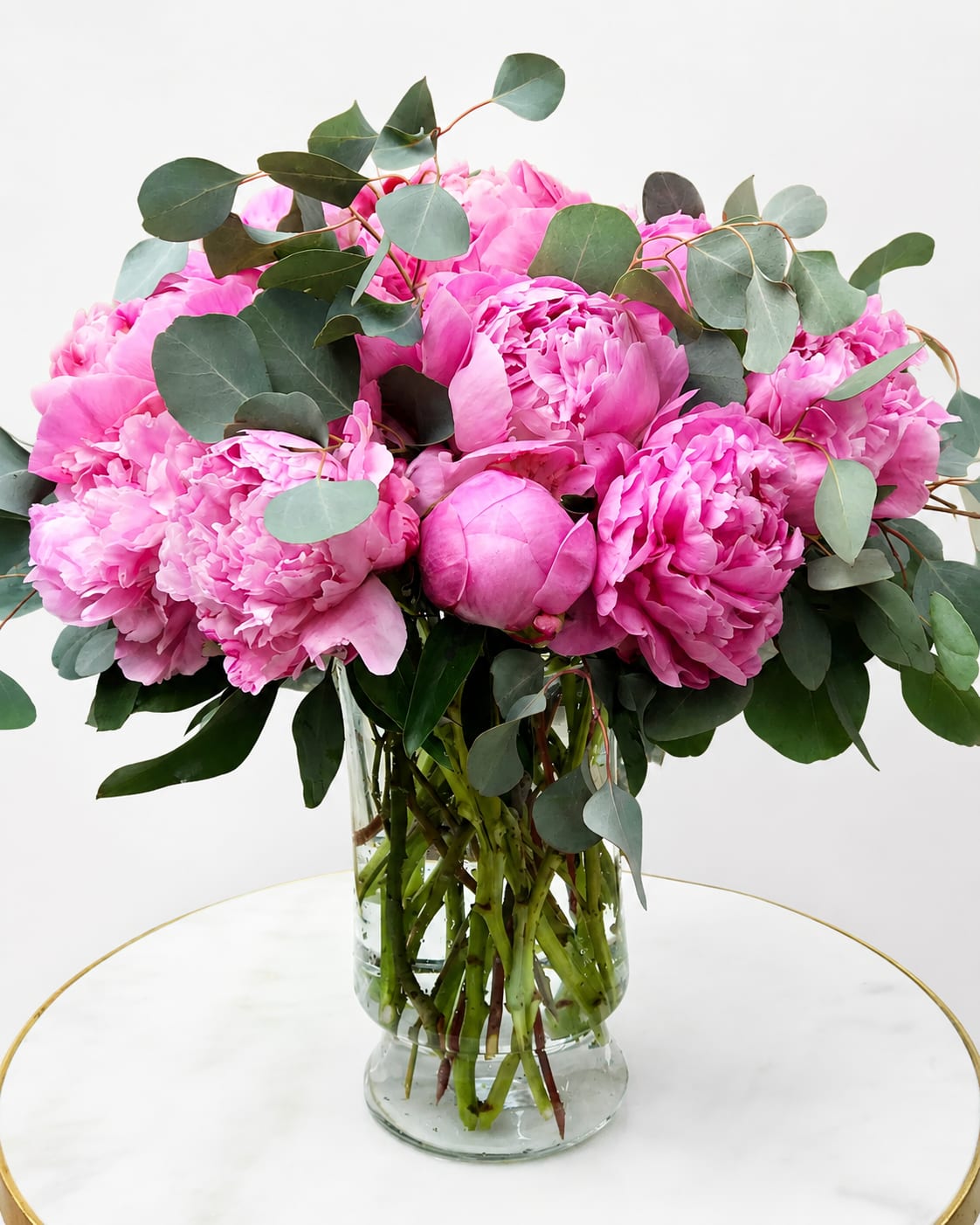 Pink Peony Floral Arrangement - This arrangement is a luxury peony design with premium pink peonies, silver dollar eucalyptus, and a modern glass vase.