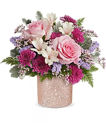 Teleflora's Blooming Brilliant Bouquet - Add a touch of sparkle to Mom's day with our shimmering glass cylinder, boasting a crushed glass texture and a soft ballerina pink hue, perfect for showcasing a dreamy Mother's Day bouquet. Elevate mom's day with our shimmering glass cylinder, boasting a crushed glass texture in ballet pink, perfectly complementing a bouquet of pink roses, ivory alstroemeria, purple cushion spray chrysanthemums, lavender sinuata statice, pink limonium, dusty miller, and leatherleaf fern, a dazzling Mother's Day surprise.
