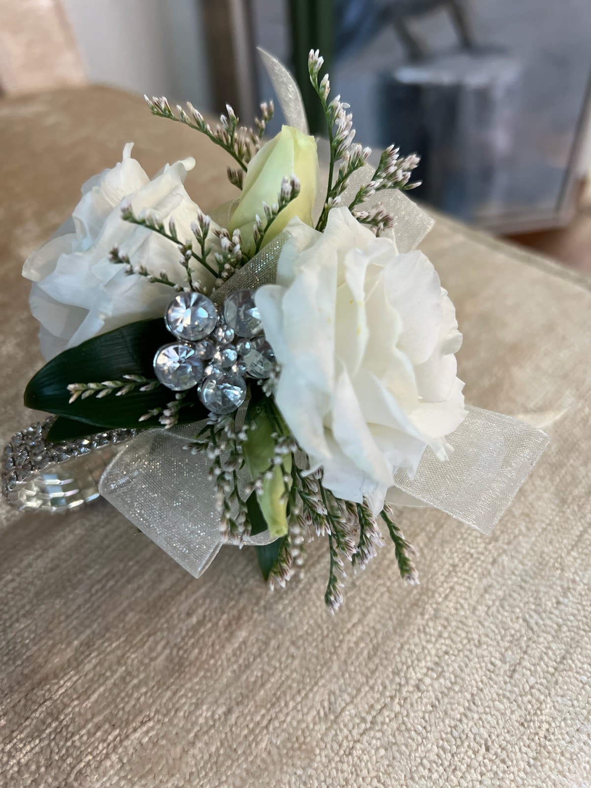 Small white rose corsage with rhinestone accents and sheer ribbon