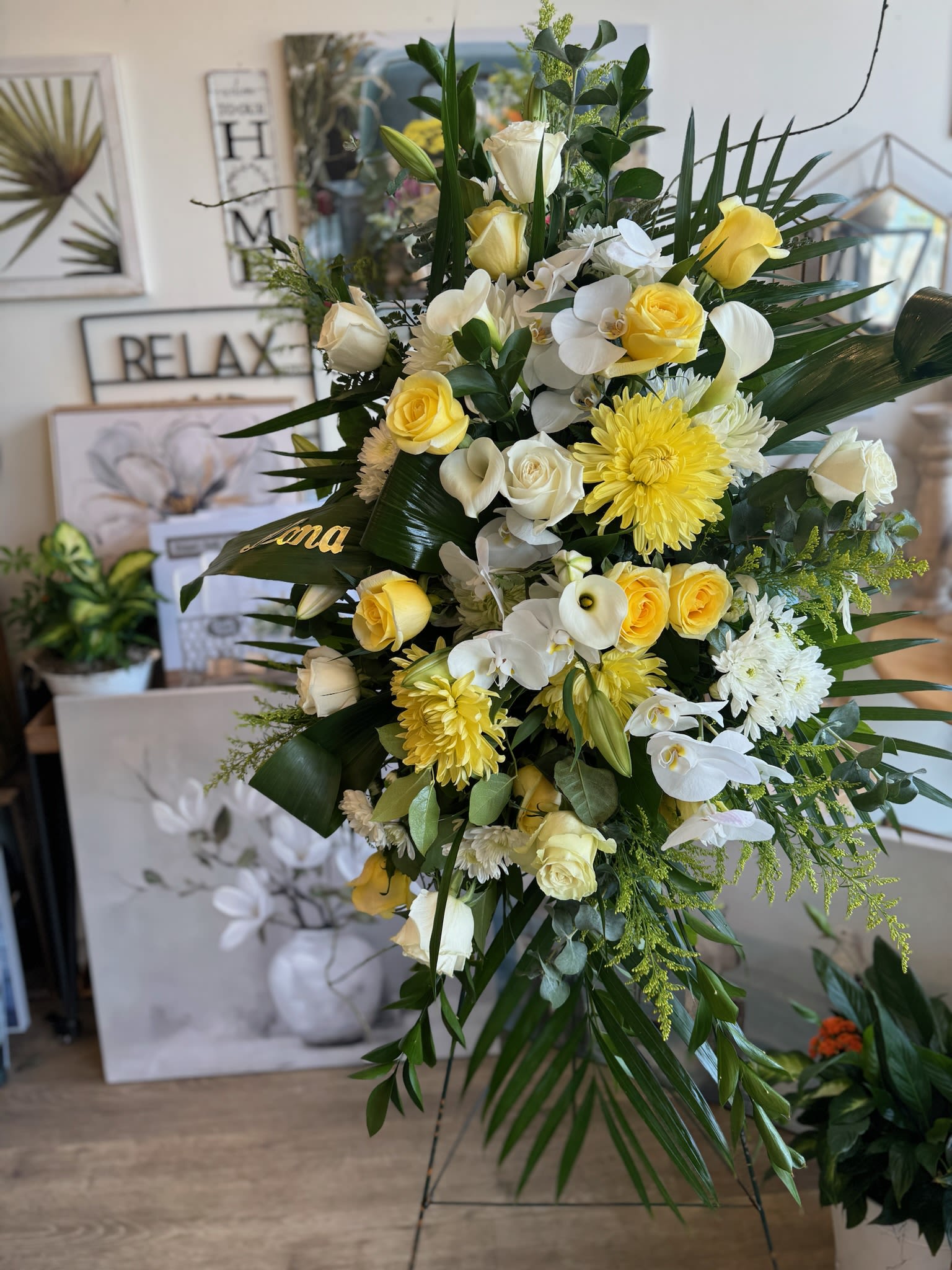 Tall floral spray with yellow and white roses and orchids