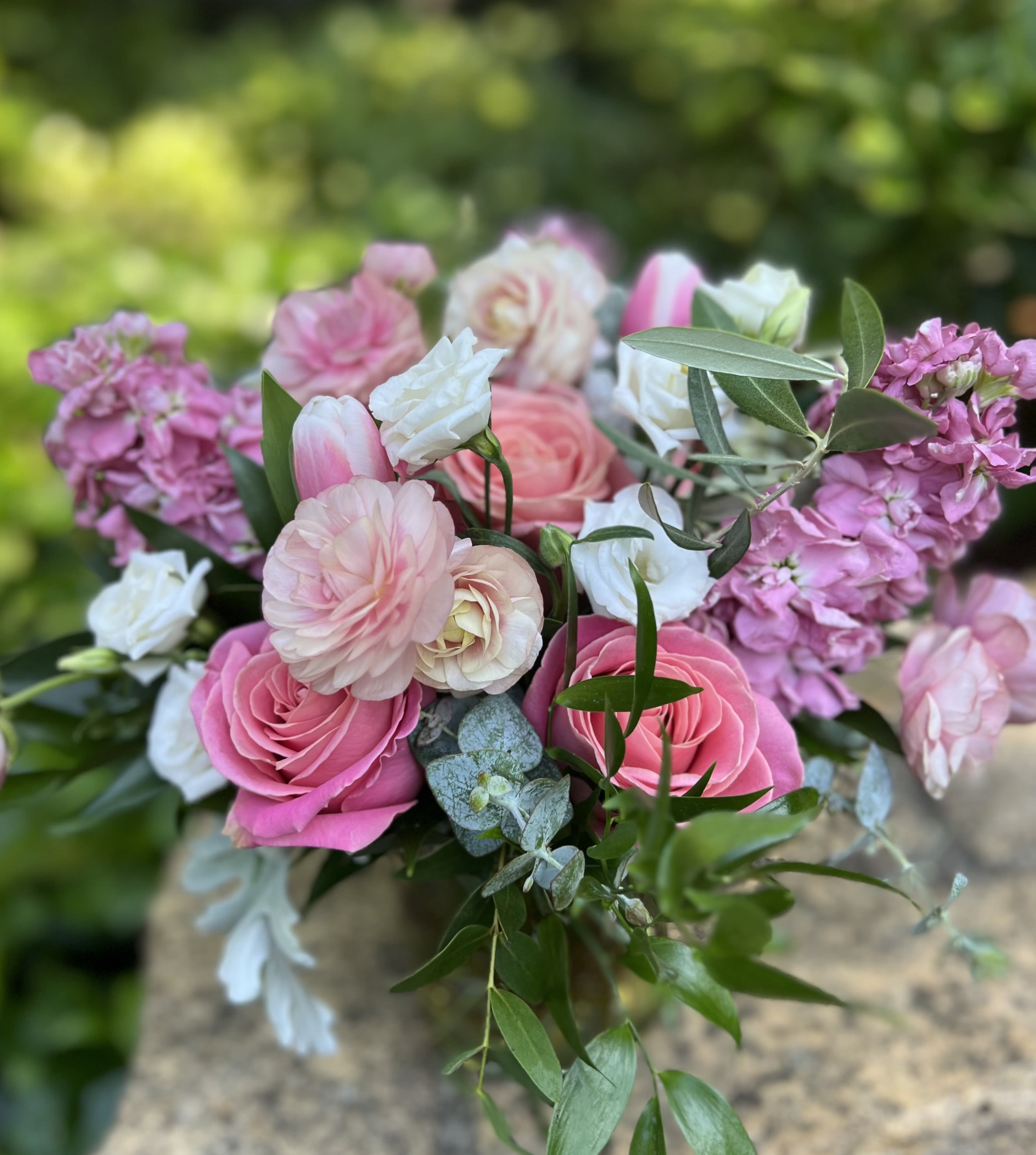 Pink and white bouquet of roses and ranunculus with greenery