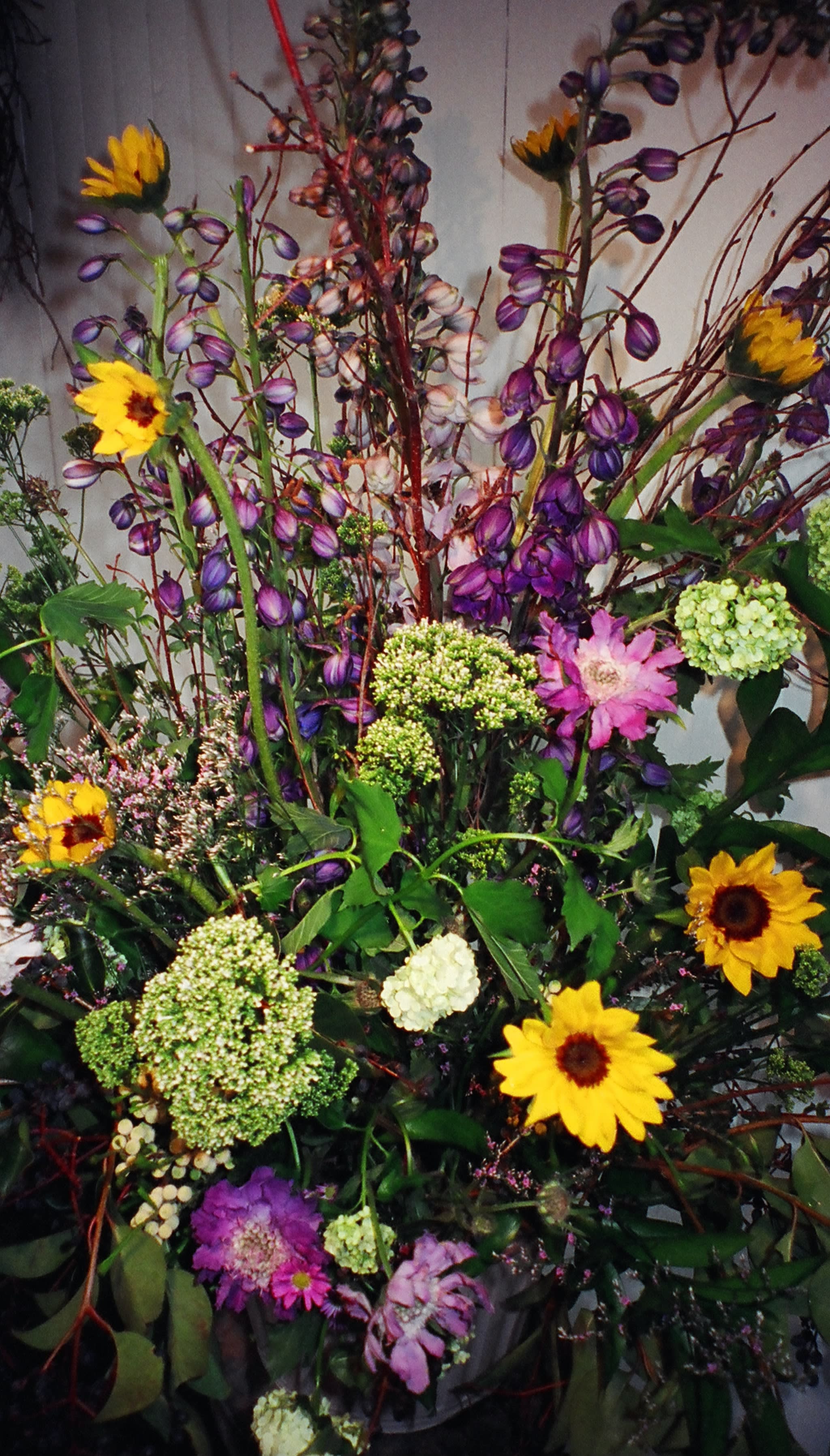 Tall mixed bouquet with yellow sunflowers and purple blooms