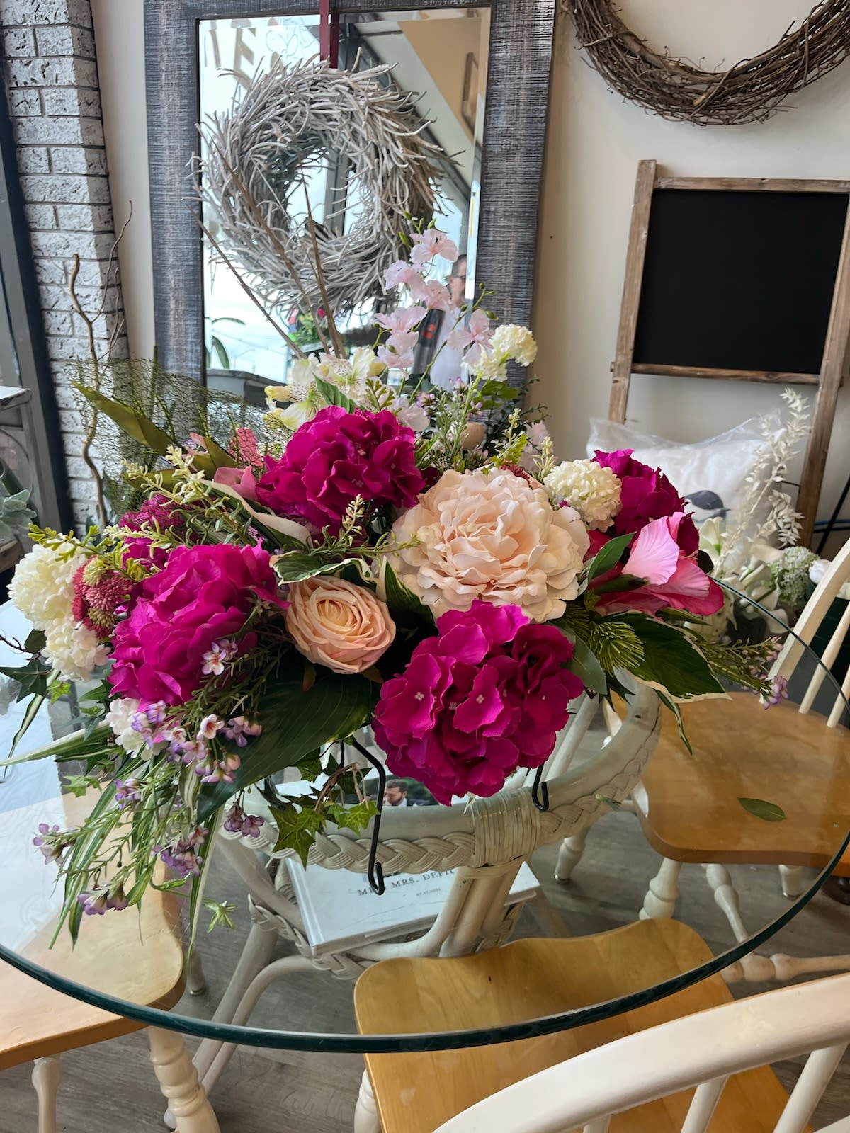 Large mixed bouquet with pink and cream flowers in a white basket