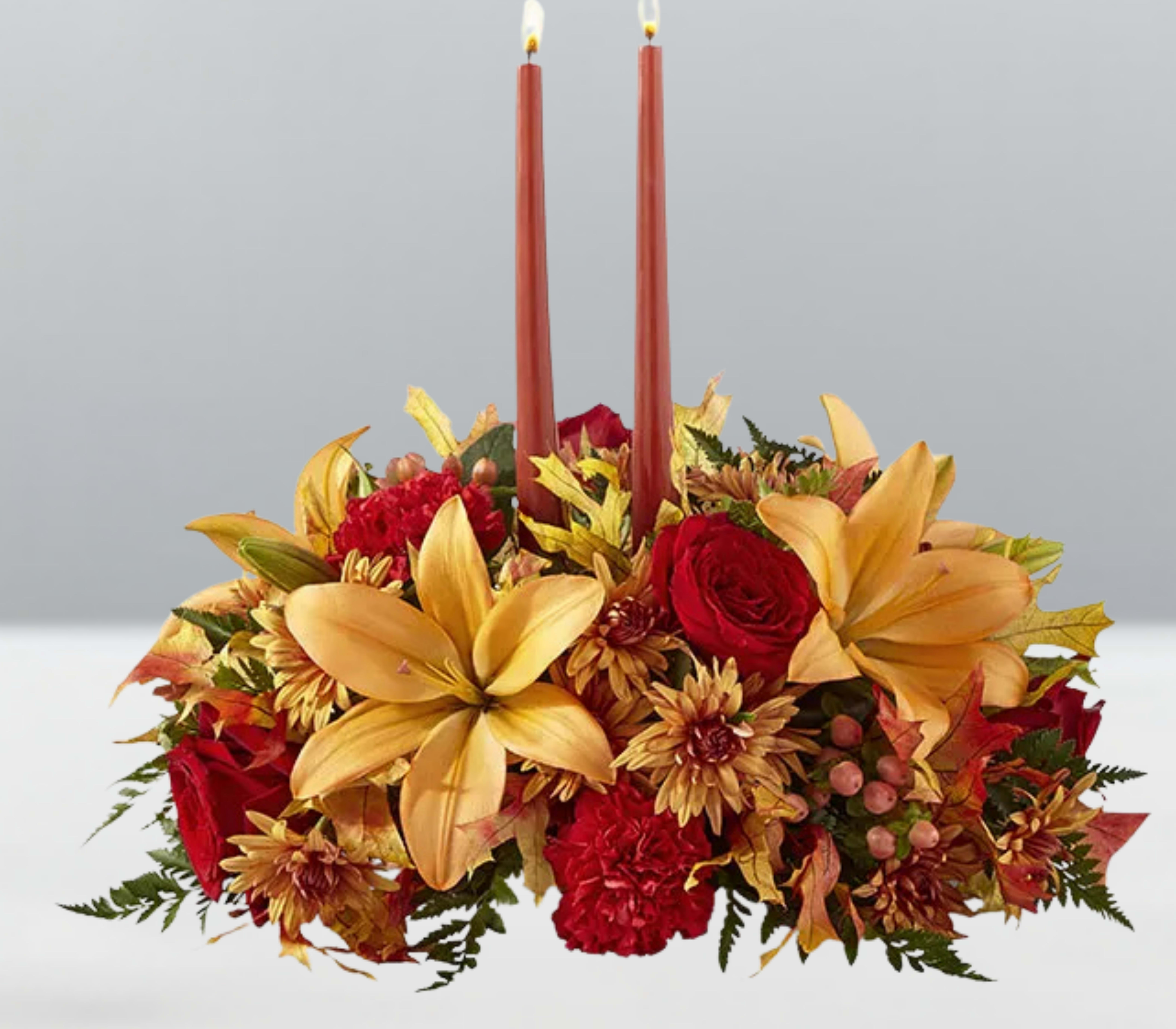 Grateful blooms -  Grateful Blooms  A radiant reflection of autumn’s generosity—Grateful Blooms gathers sunflowers, orange roses, pinecones, and berry accents into a lush, textured display of seasonal beauty. With each petal and leaf, this arrangement whispers thanks and joy, making it a perfect centerpiece for gatherings, gifts, or quiet moments of appreciation. Designed to evoke warmth and wonder, it’s a floral embrace for the season of gratitude.