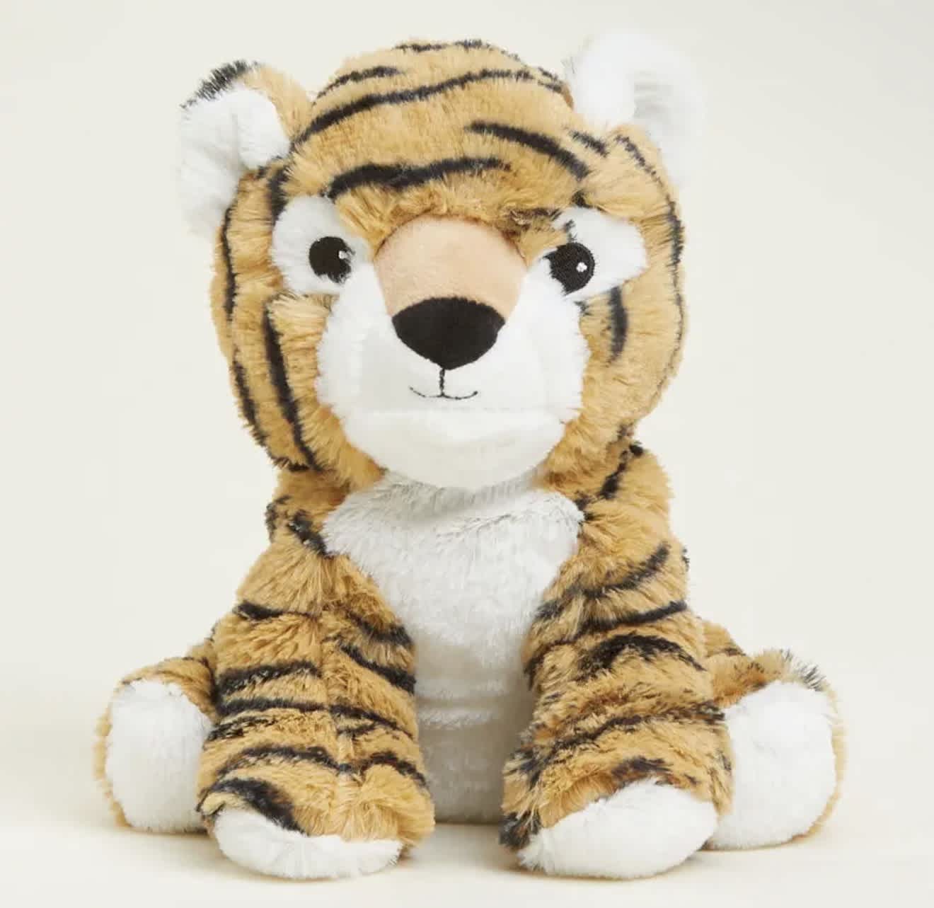 Plush tiger stuffed animal sitting against a plain background