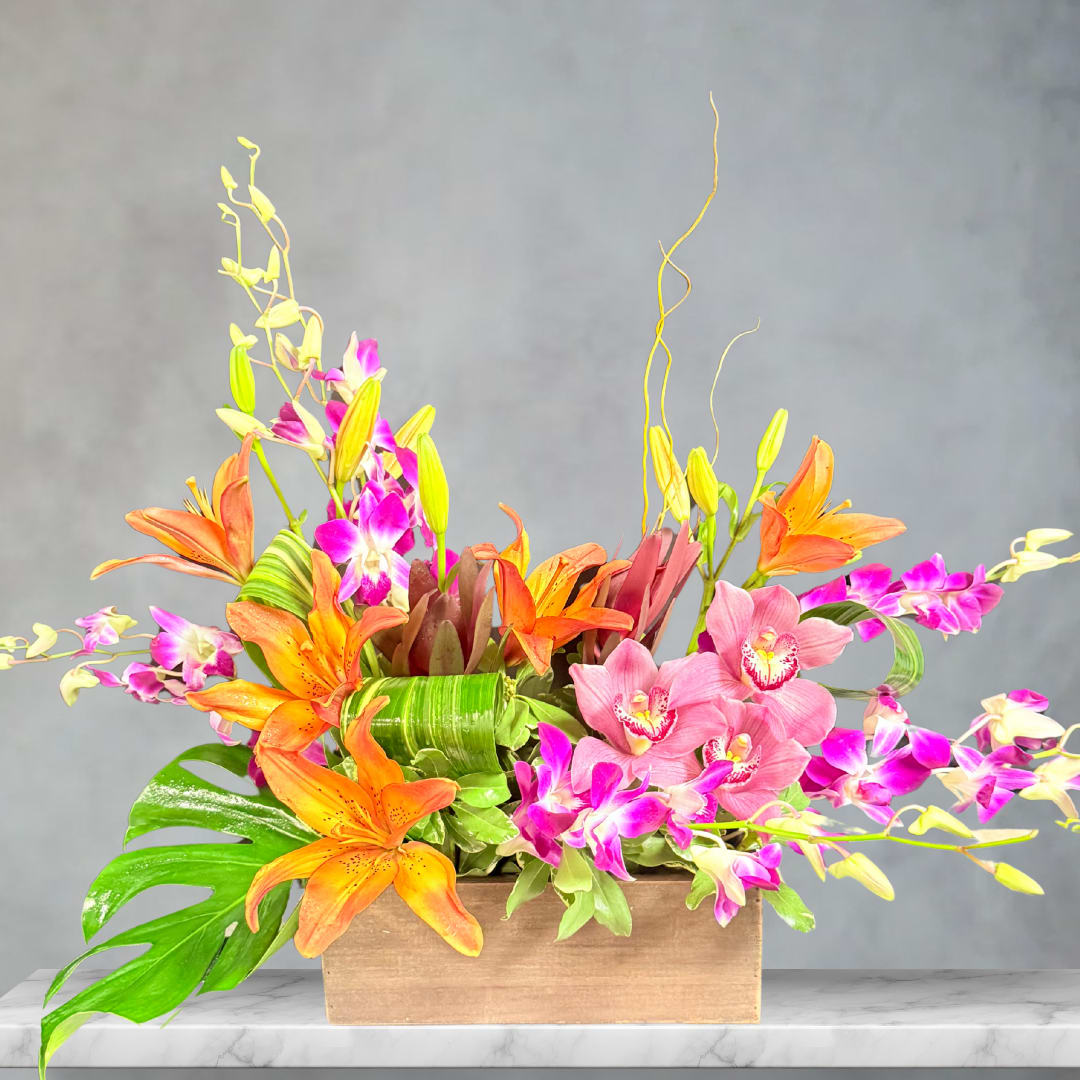 Orange lilies and pink orchids arranged in a wooden box