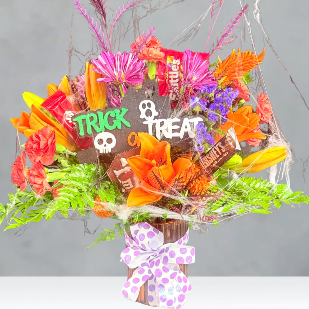 Halloween bouquet with candy bars and bright orange flowers in a vase