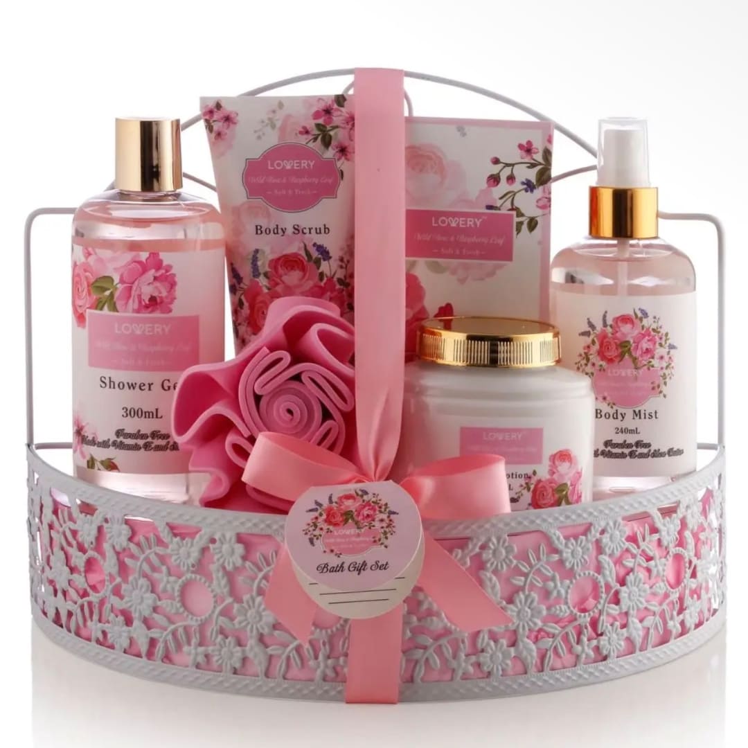 Pink bath gift set in a decorative basket with bottles, scrub, and ribbon