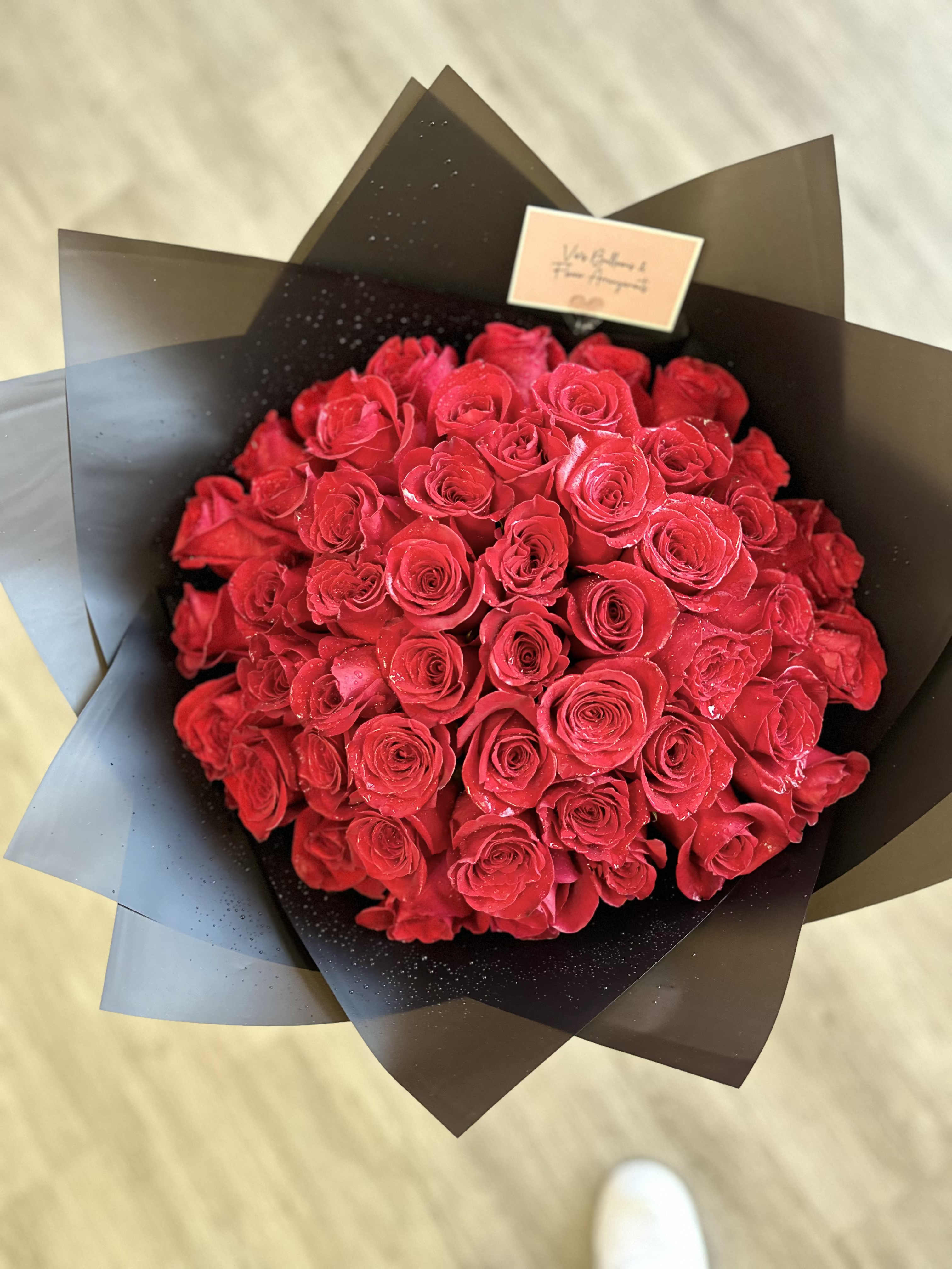 Royal Red Roses Bouquet - This luxurious bouquet features stunning red roses wrapped in elegant black paper, creating a striking contrast that exudes sophistication and elegance. Perfect for expressing love, admiration, or celebration, these exquisite roses make a regal statement for any occasion.