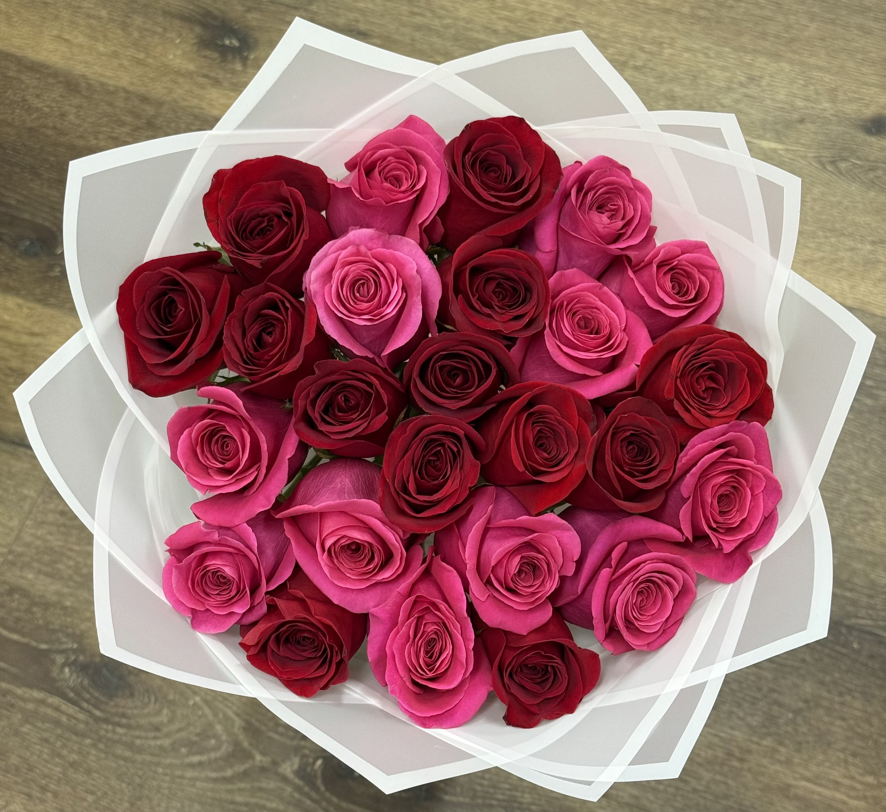 Sweetheart Swirl Bouquet - The Sweetheart Swirl features a mix of premium red and hot pink roses. This arrangement is mounded for a dense appearance and is wrapped in white Korean paper with a white border.