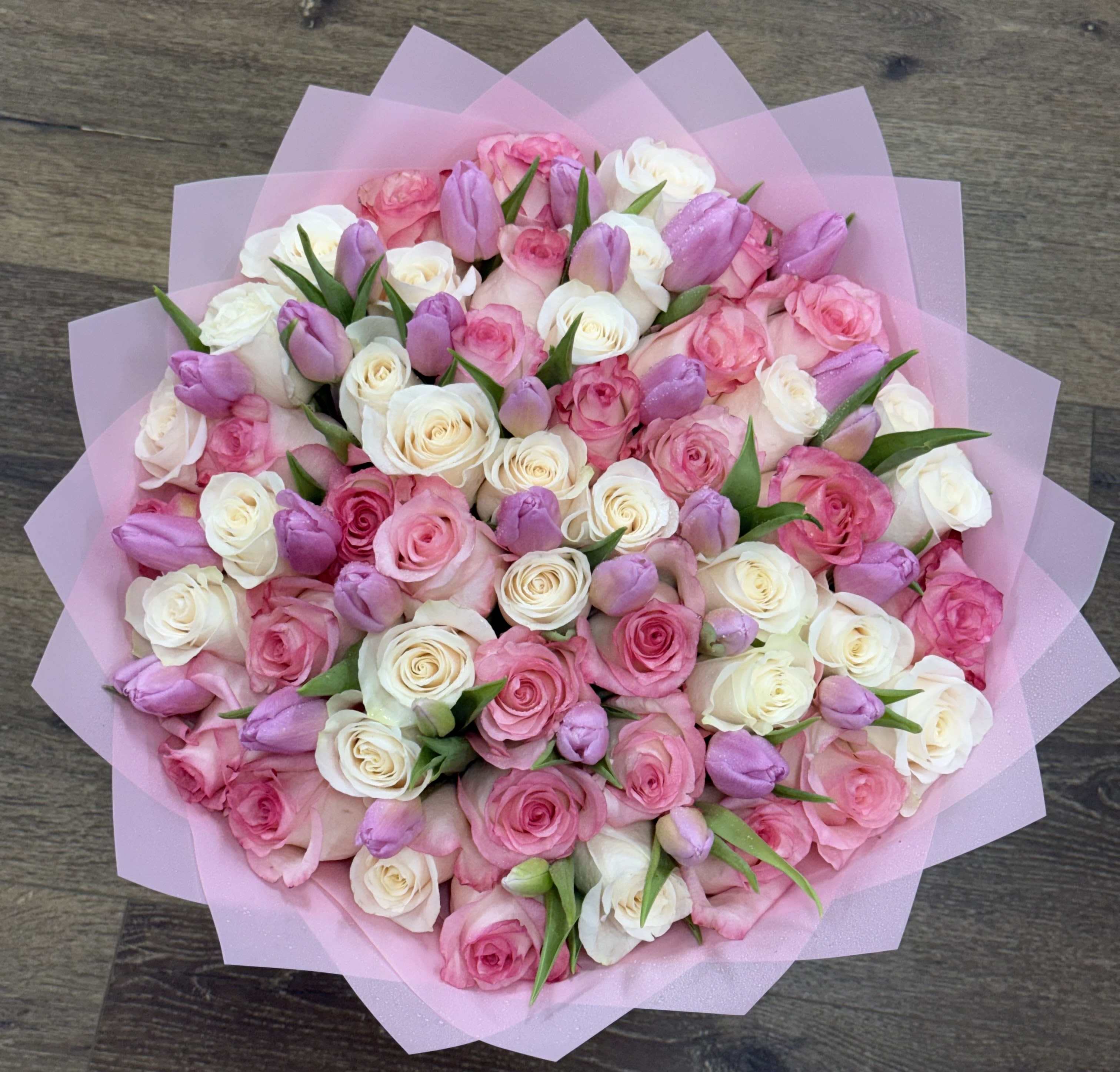 Lavender Fields Bouquet - The Lavender Fields consists of a mix of pink and white roses interspersed with purple tulips. This arrangement is finished in a layered pink Korean paper wrap.