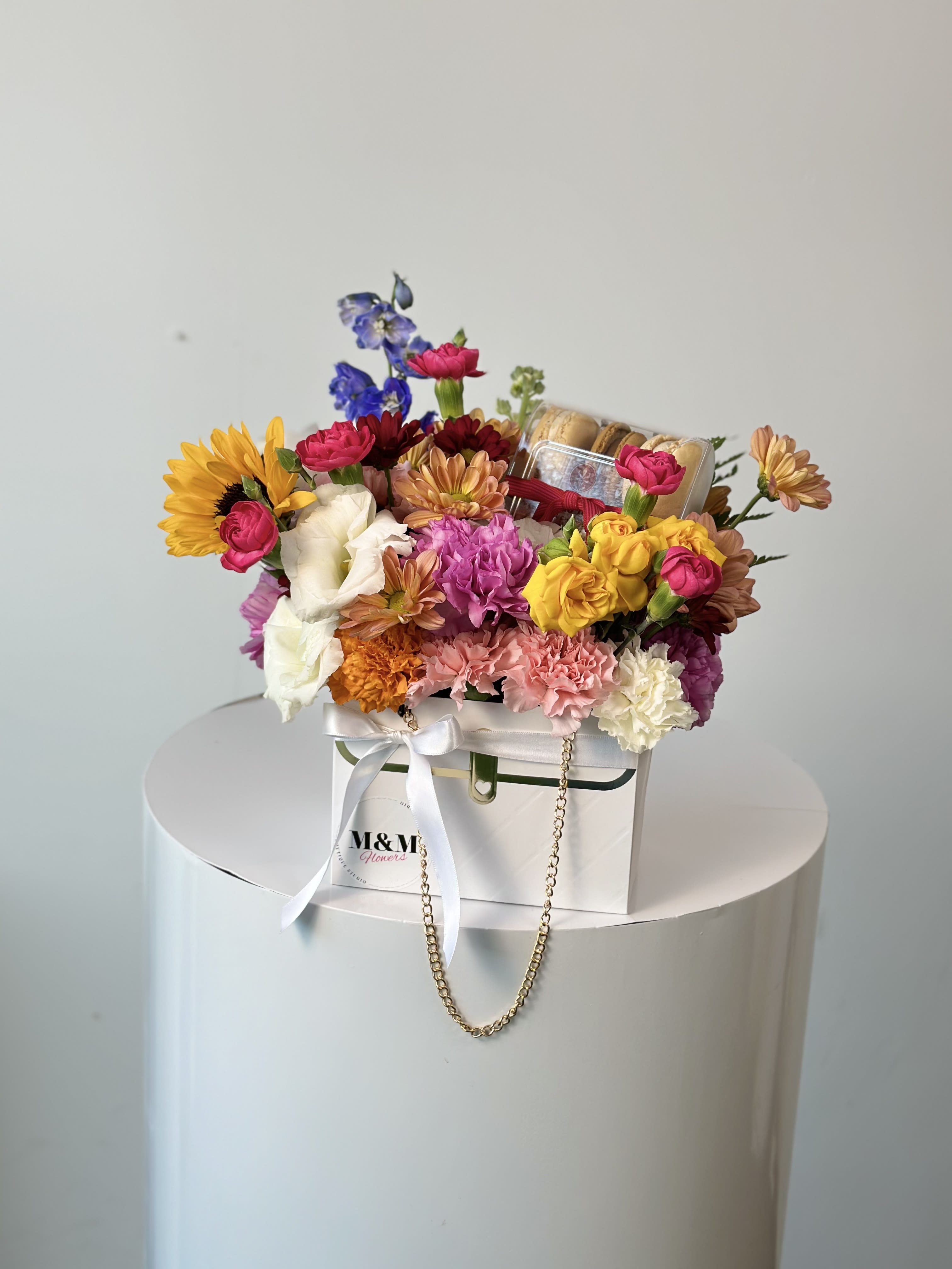 Colorful mixed flower arrangement in a white gift box with a ribbon