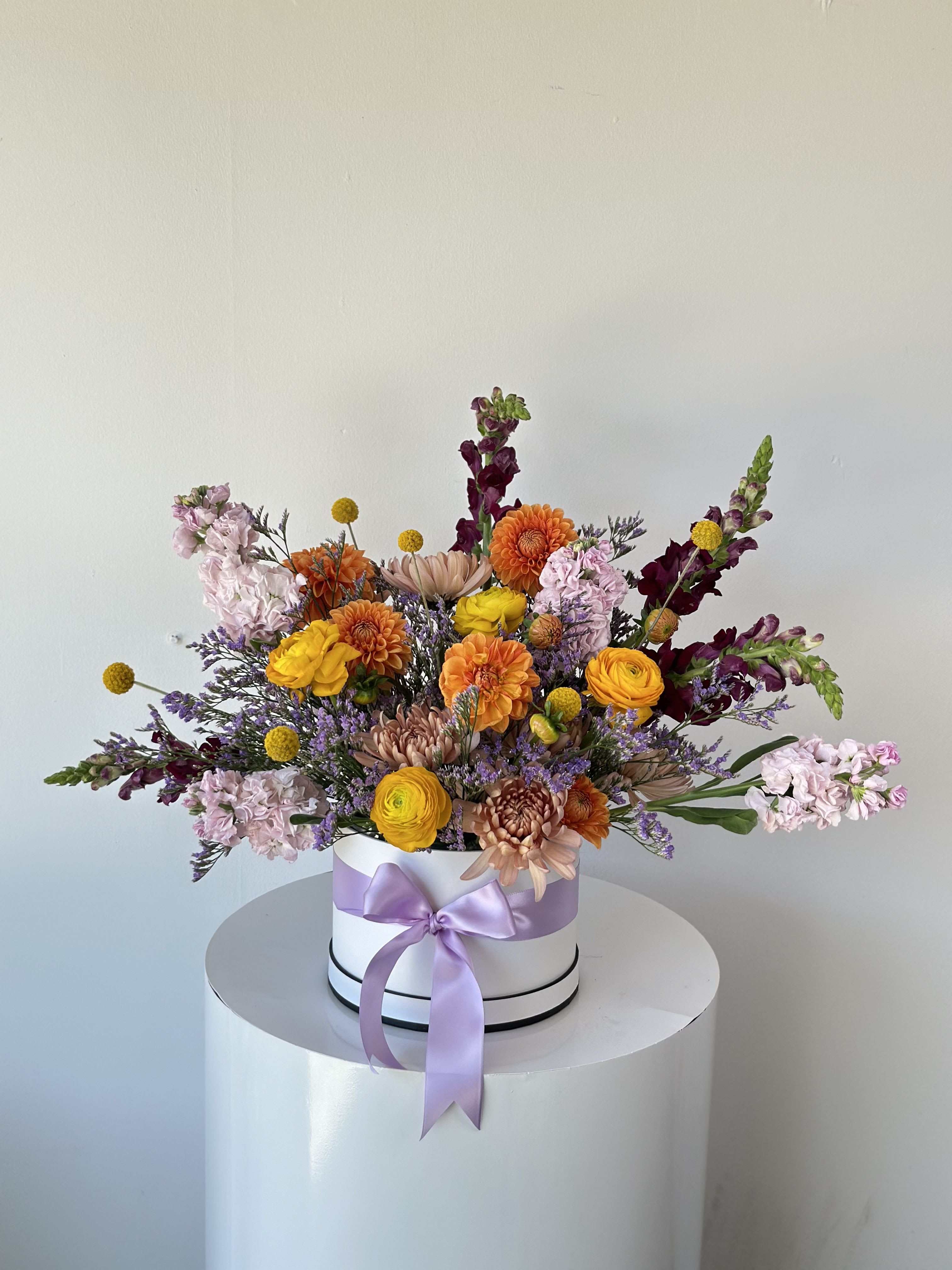 Mixed bouquet in a white hat box with a lavender ribbon
