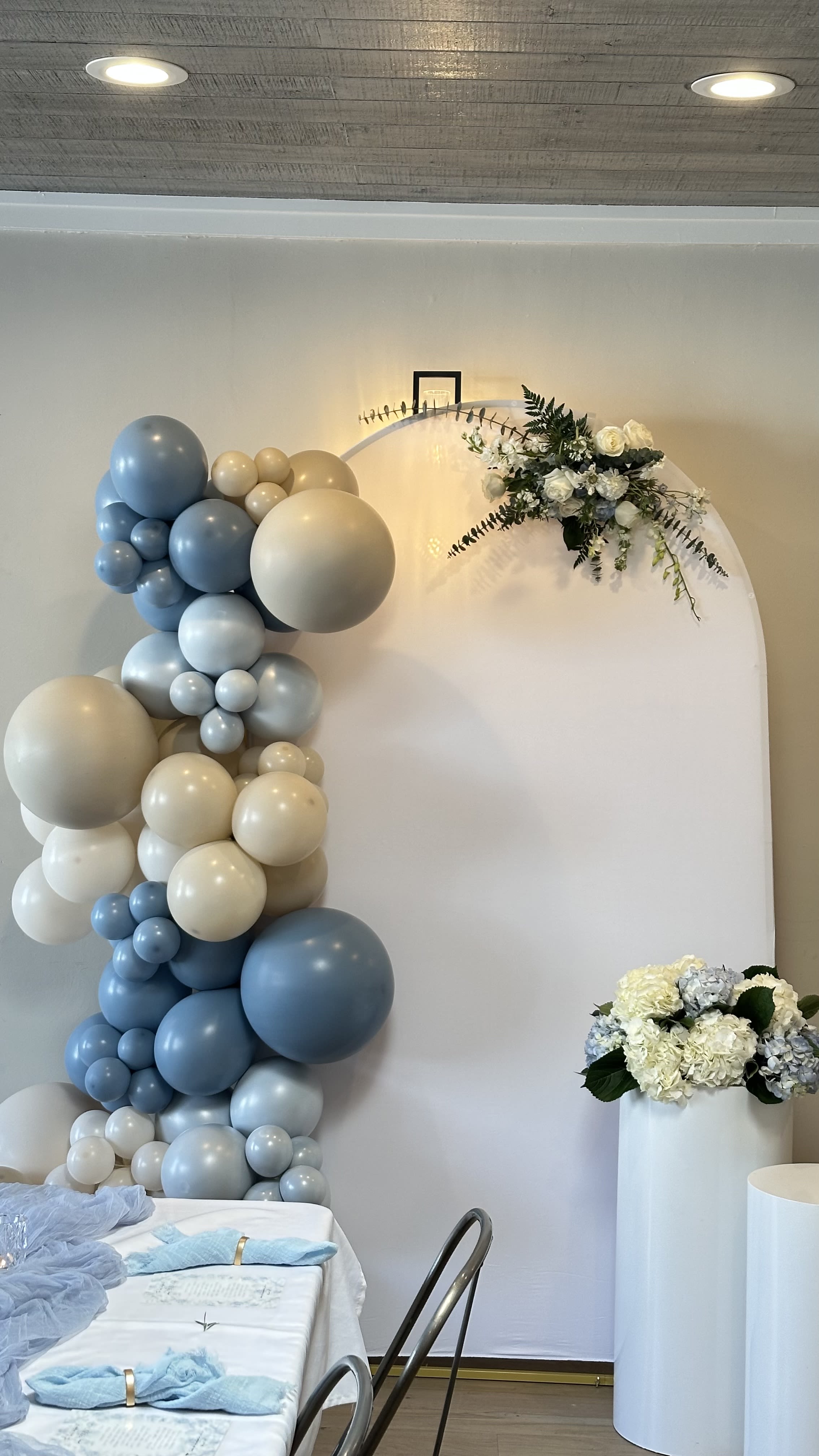 Blue and cream balloon arch with white floral accents