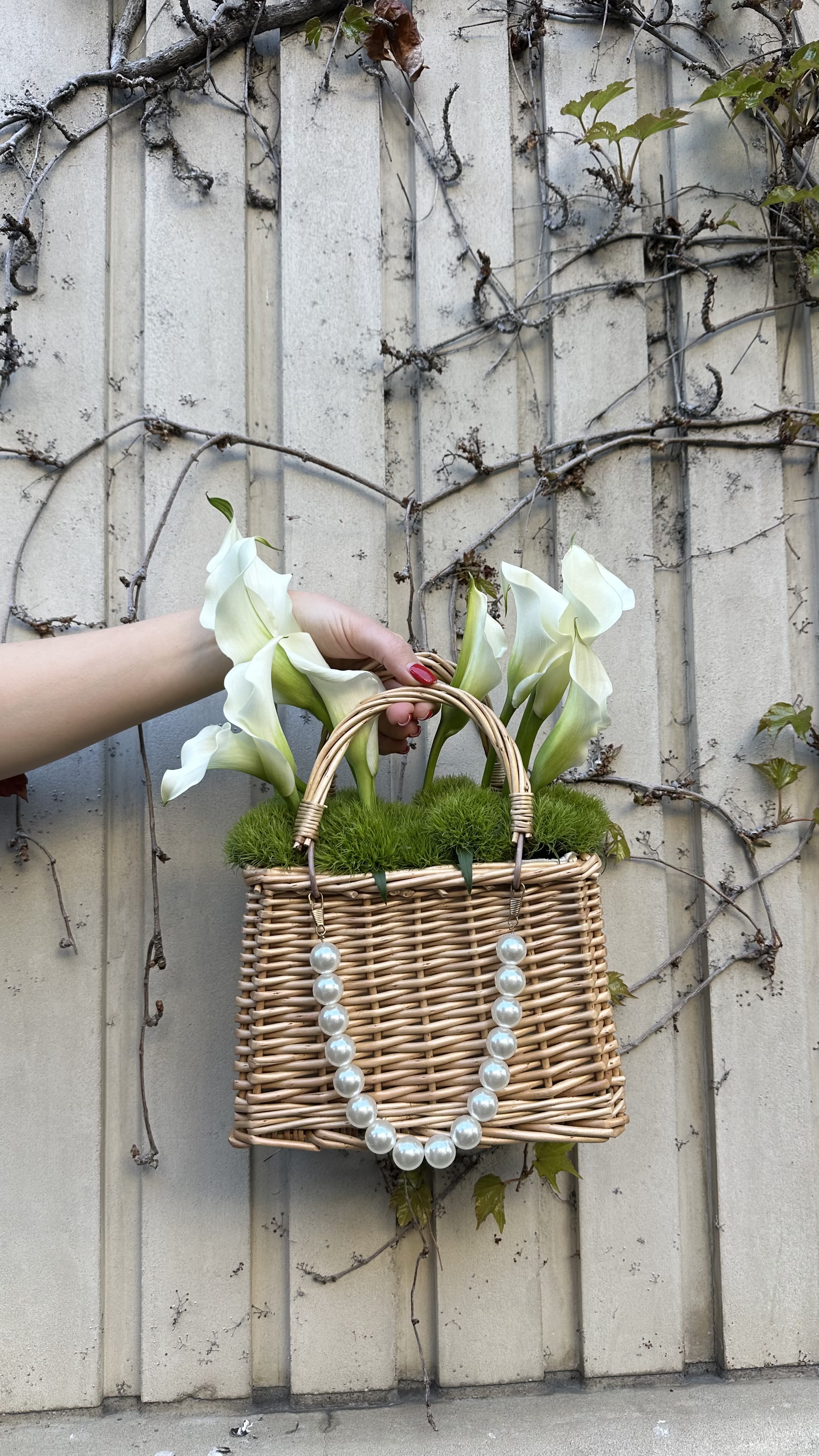 Wicker basket with white calla lilies and pearl handles