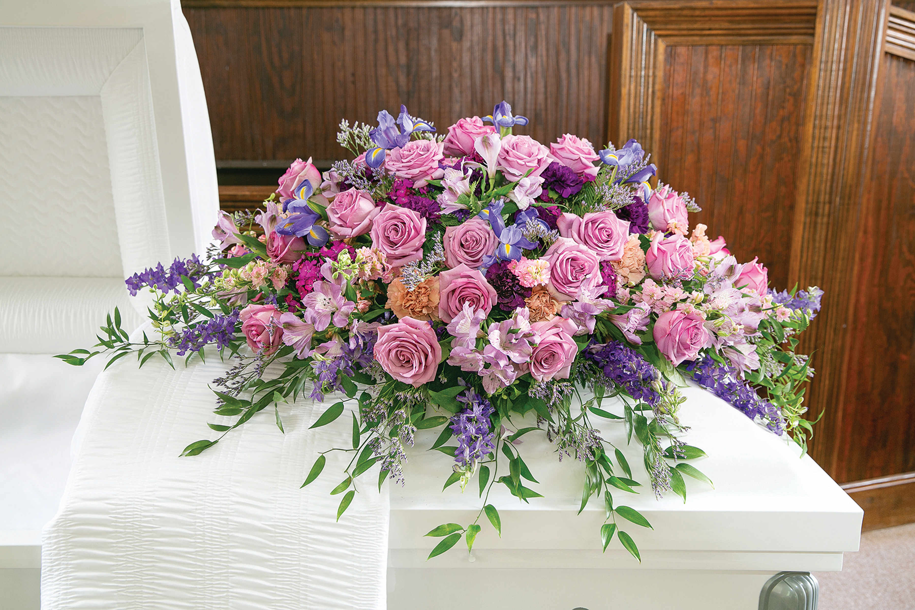 Large pink and purple floral casket spray with roses and lilies