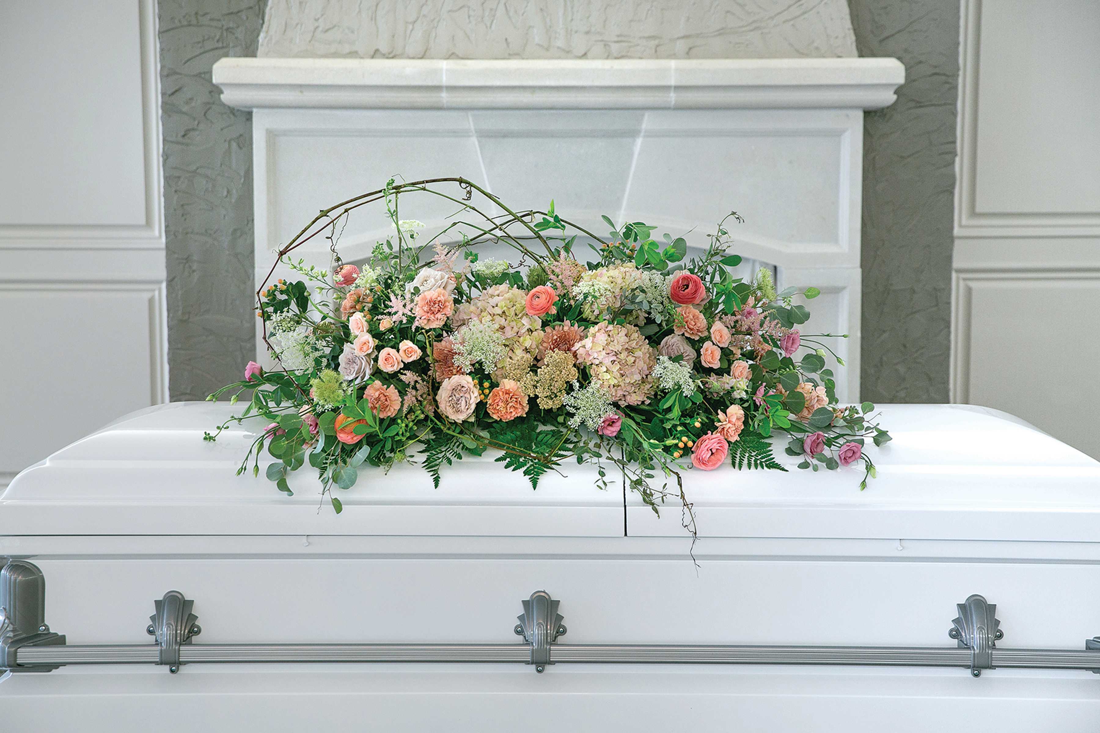 Pastel floral arrangement on a white casket