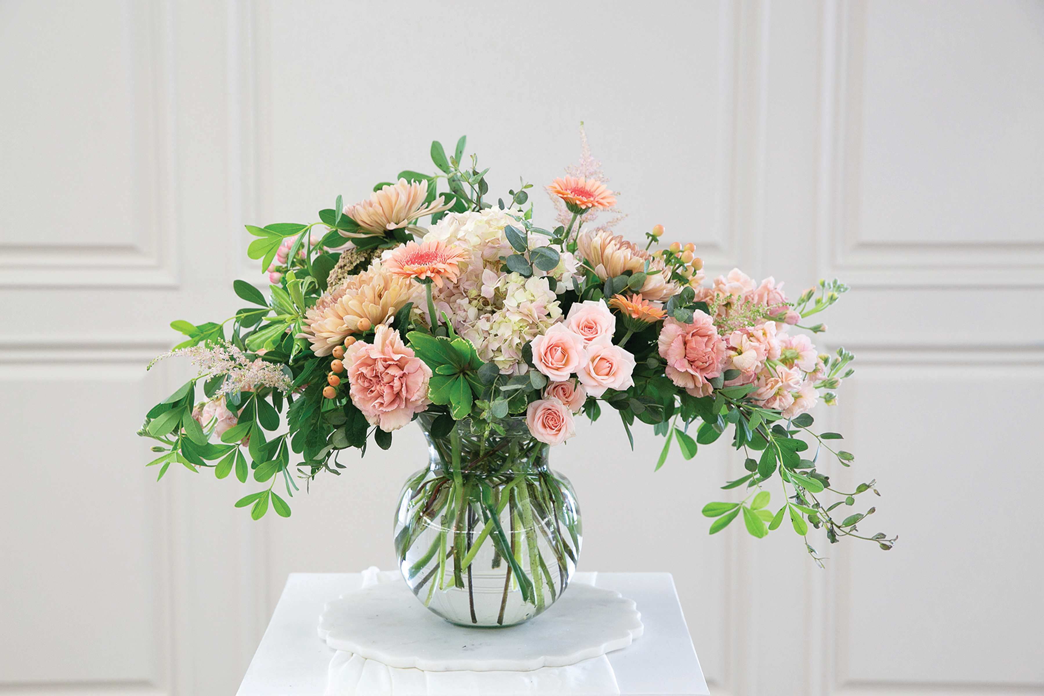 Peach and pink floral arrangement in a clear glass vase
