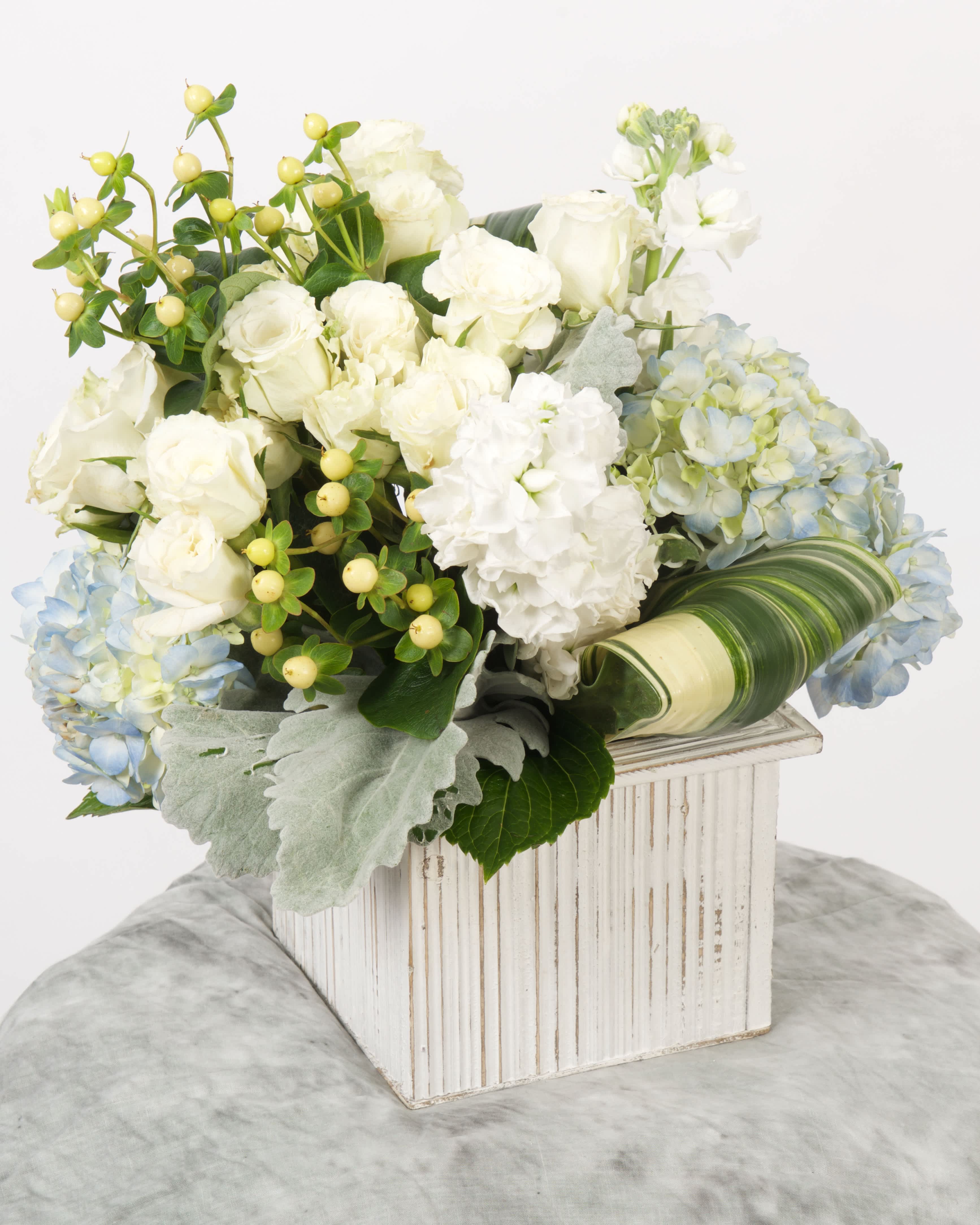 BEACH HOUSE - Airy, textural, and coastal-inspired — Beach House brings seaside serenity into any space. This arrangement features a fresh mix of white hydrangea, cream roses, pale blue delphinium, lisianthus, and wispy seasonal greens. The palette is soft and natural, evoking driftwood, seashells, and salty breezes.  Perfect for housewarmings, modern beach weddings, or effortlessly elegant home decor. A top choice for customers in and around San Diego searching for coastal floral arrangements, beach-themed flowers, or elegant white and blue bouquets with same-day delivery.