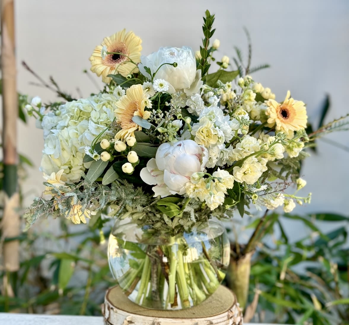 Bouquet of pale yellow and white flowers in a clear glass vase