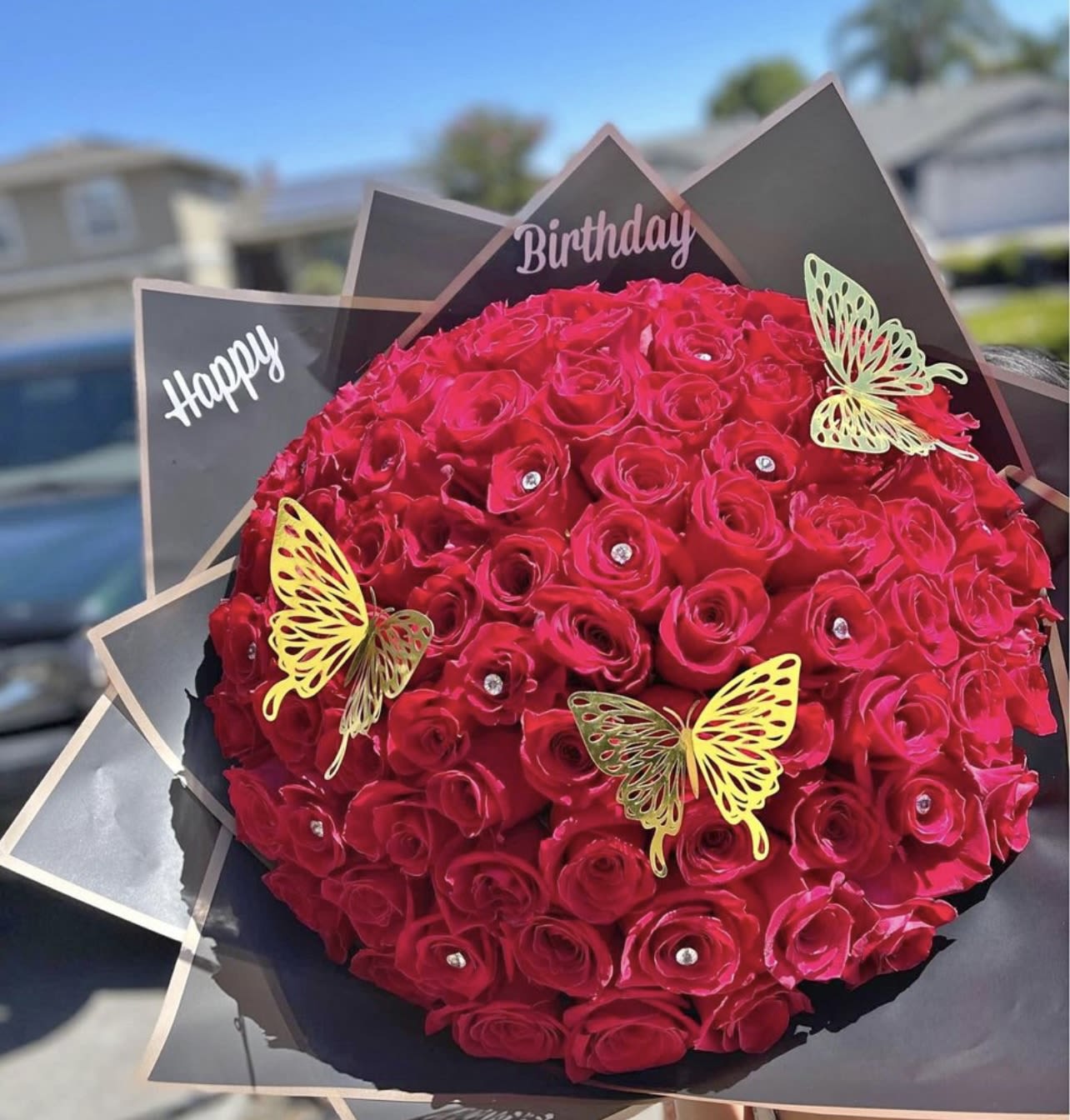 Round bouquet of red roses with butterfly decorations and birthday signs