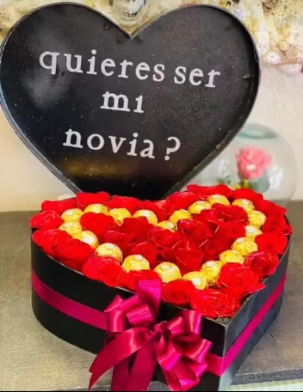 Heart-shaped box of red and yellow roses with a Spanish message inside the lid