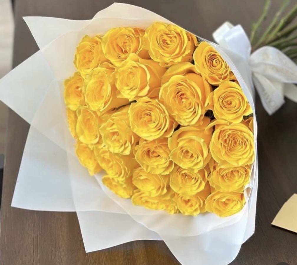 Bouquet of yellow roses wrapped in white paper