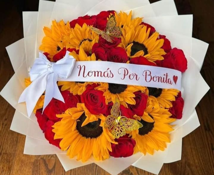 Bouquet of red roses and yellow sunflowers with a white ribbon