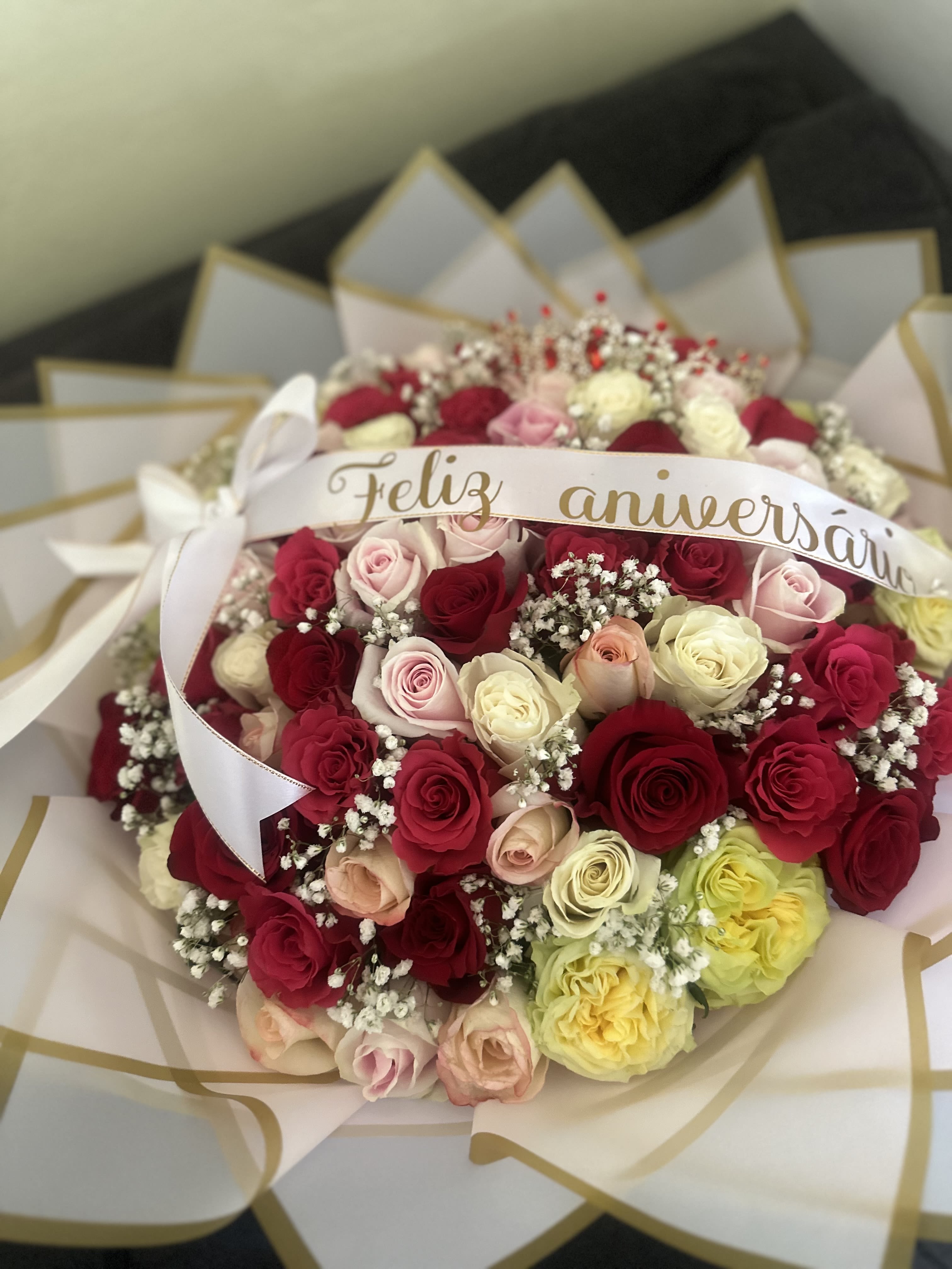 Bouquet of multicolored roses with a "Feliz aniversario" ribbon