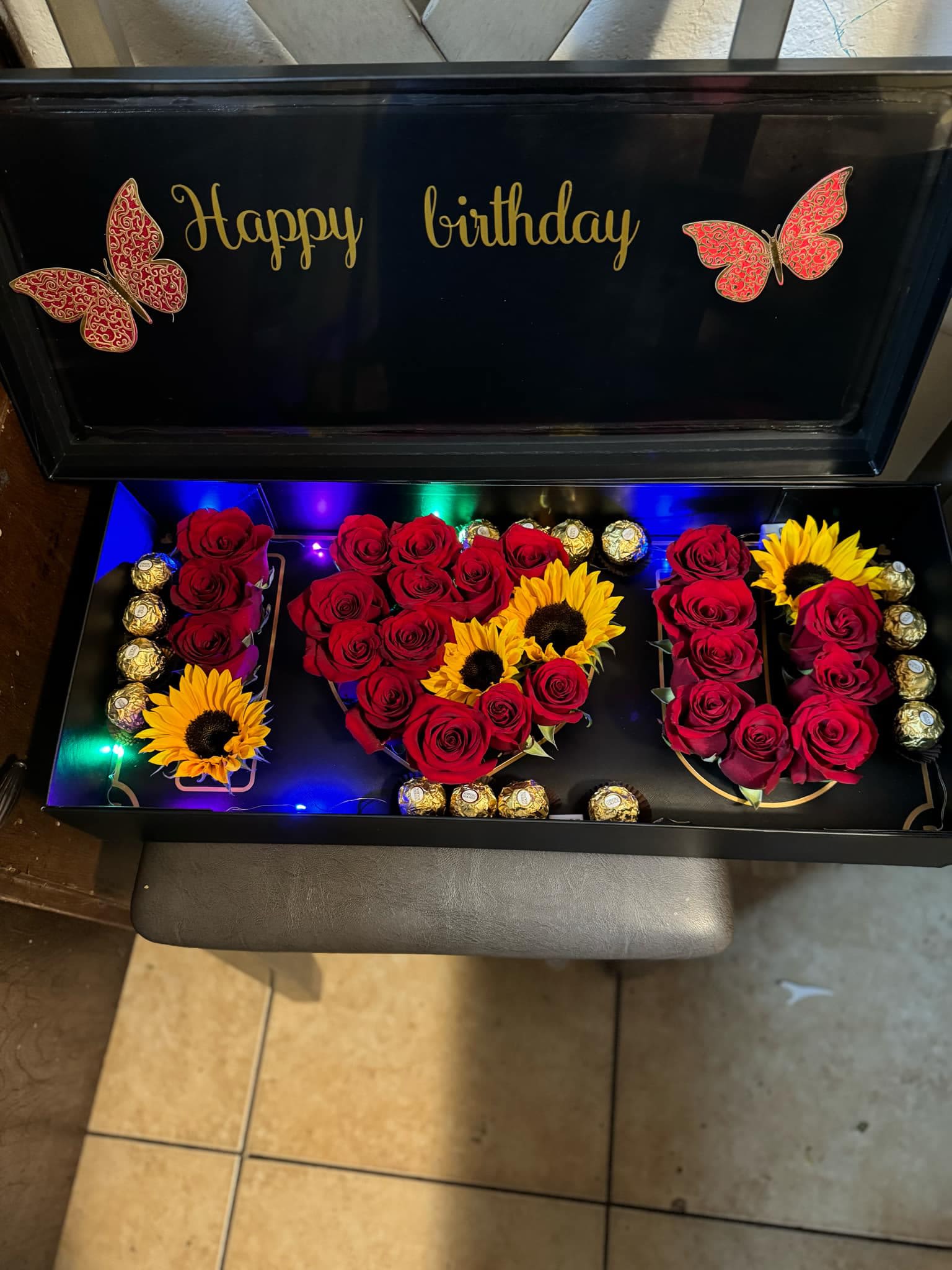 Birthday gift box with red roses, sunflowers, and chocolates