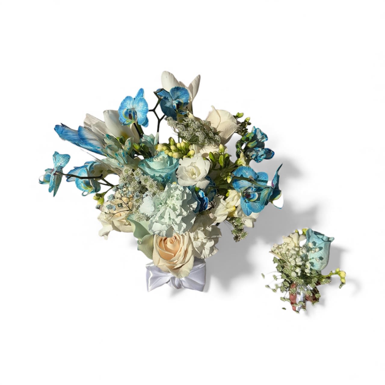 Wedding bouquet with blue orchids and cream roses, plus a matching boutonniere